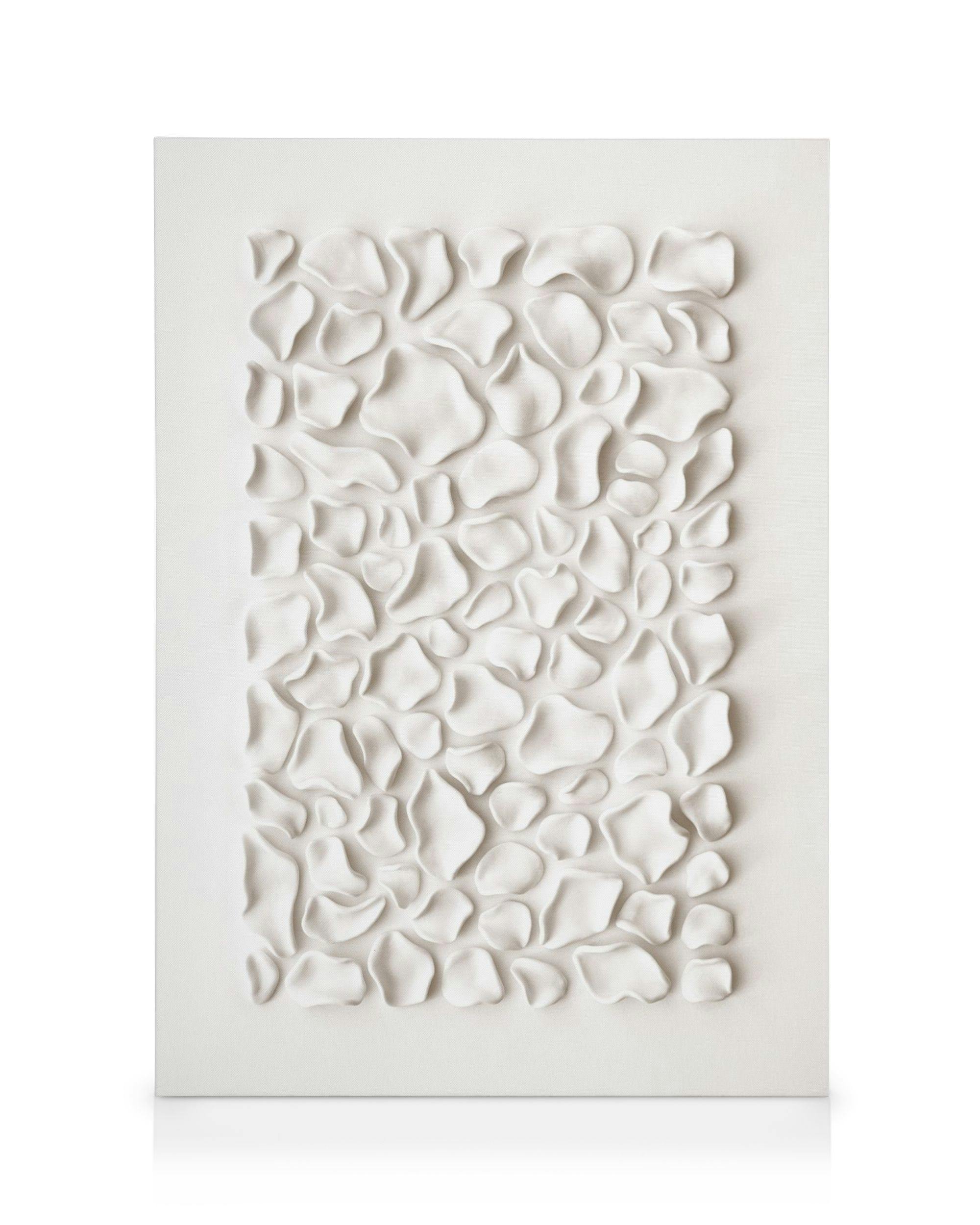 Bílý obraz na plátně s nepravidelnými, organickými tvary, připomínajícími okvětní lístky nebo oblázky, v jemných odstínech krémo
