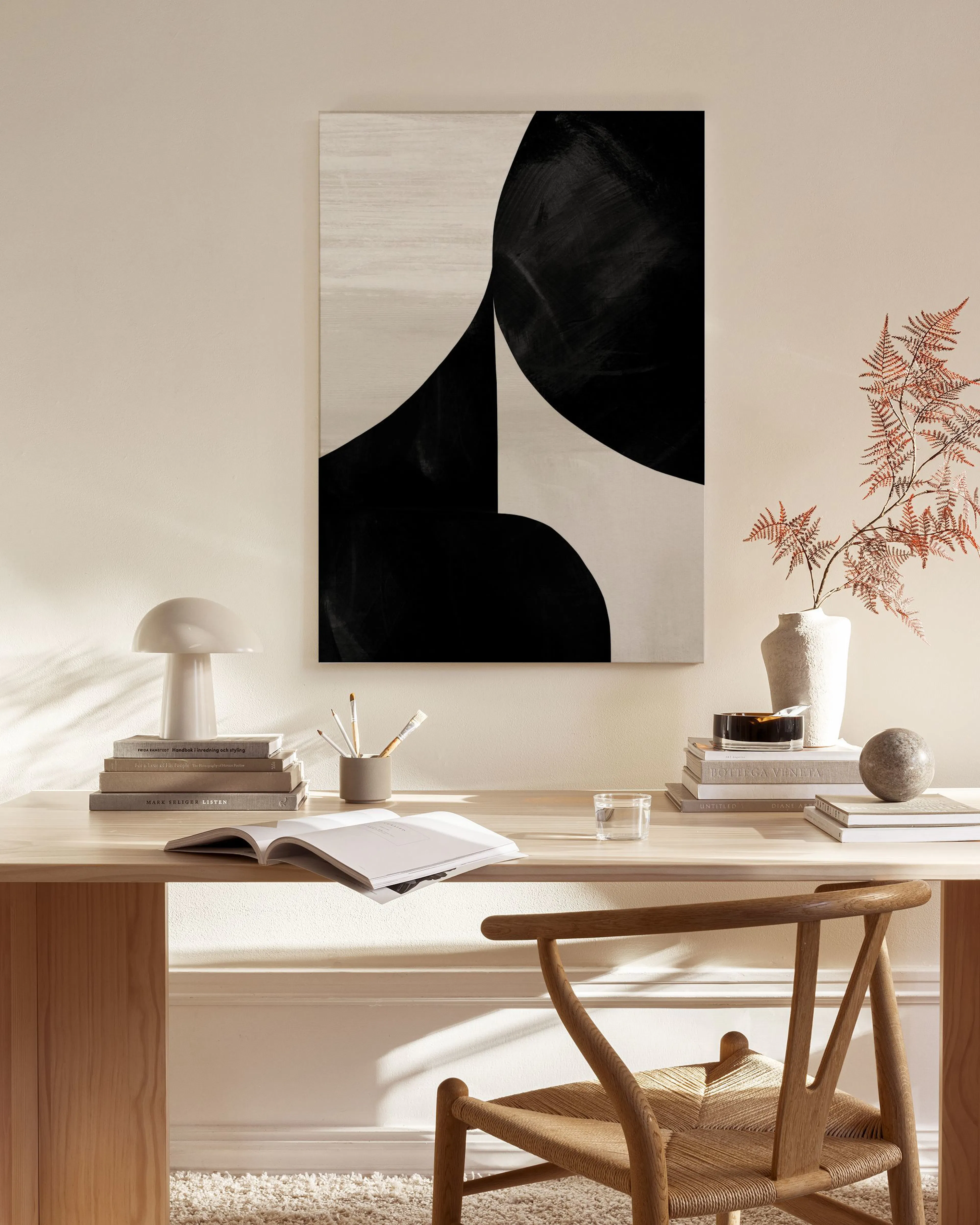 Leinwandbild mit schwarzen und beigen geometrischen Formen in einem modernen Wohnzimmer über einem Sideboard.