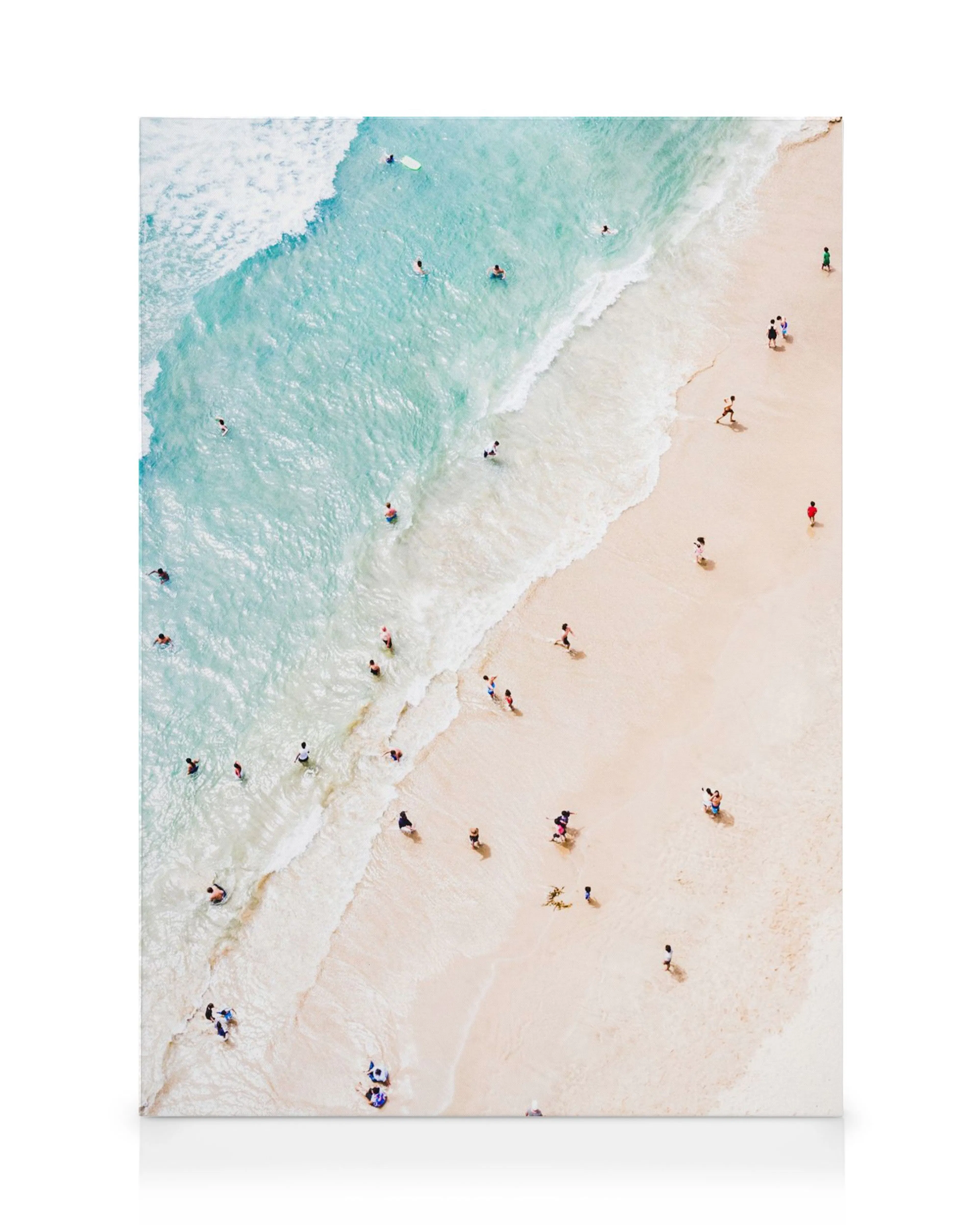 Lienzo de una playa de arena dorada y agua turquesa con bañistas, vista aérea.