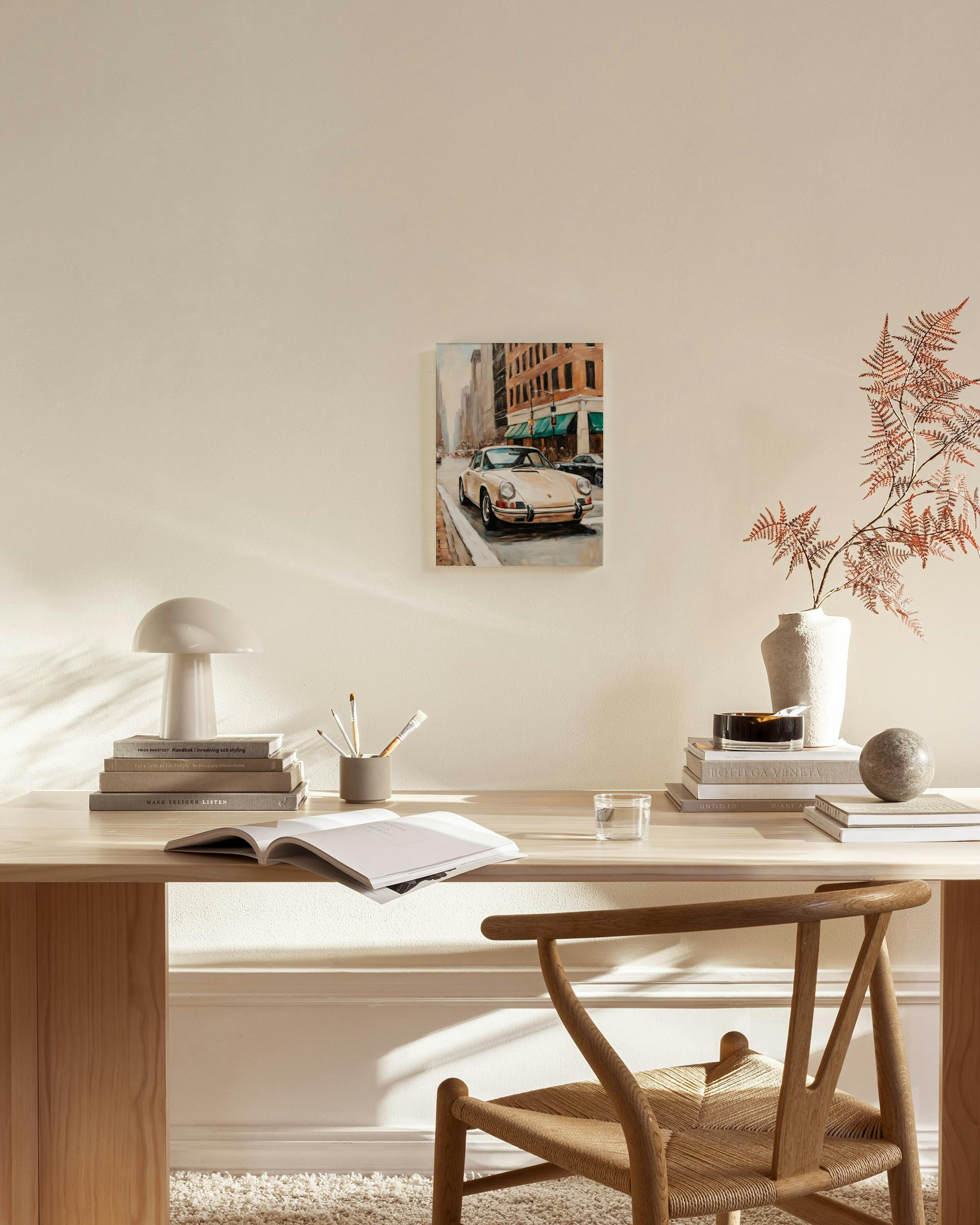 Obraz na płótnie z beżowym samochodem na ulicy, wiszący nad drewnianą szafką w minimalistycznym salonie.