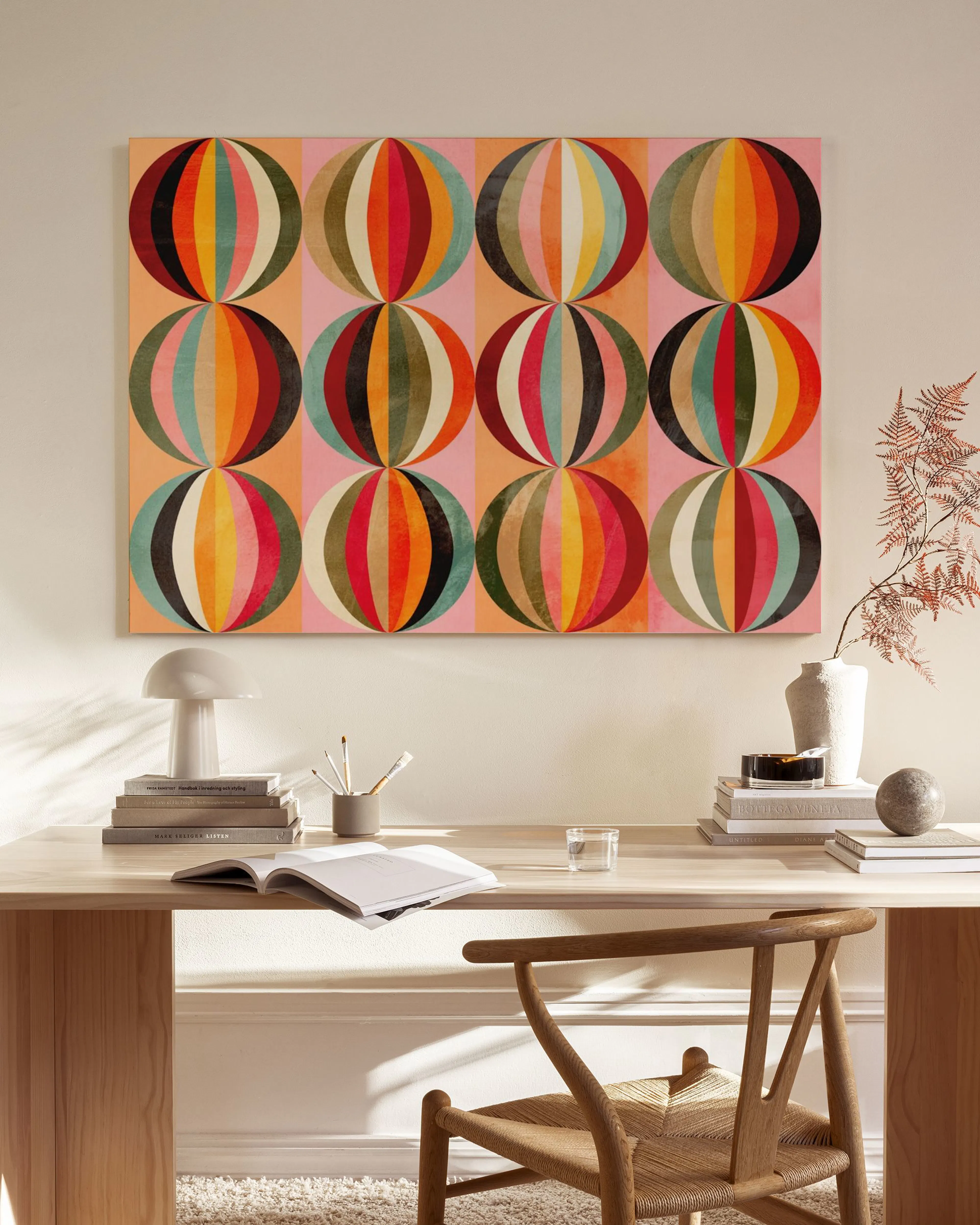 Vibrant mid-century modern canvas print with colourful concentric circles, displayed above a wooden console table in a stylish l