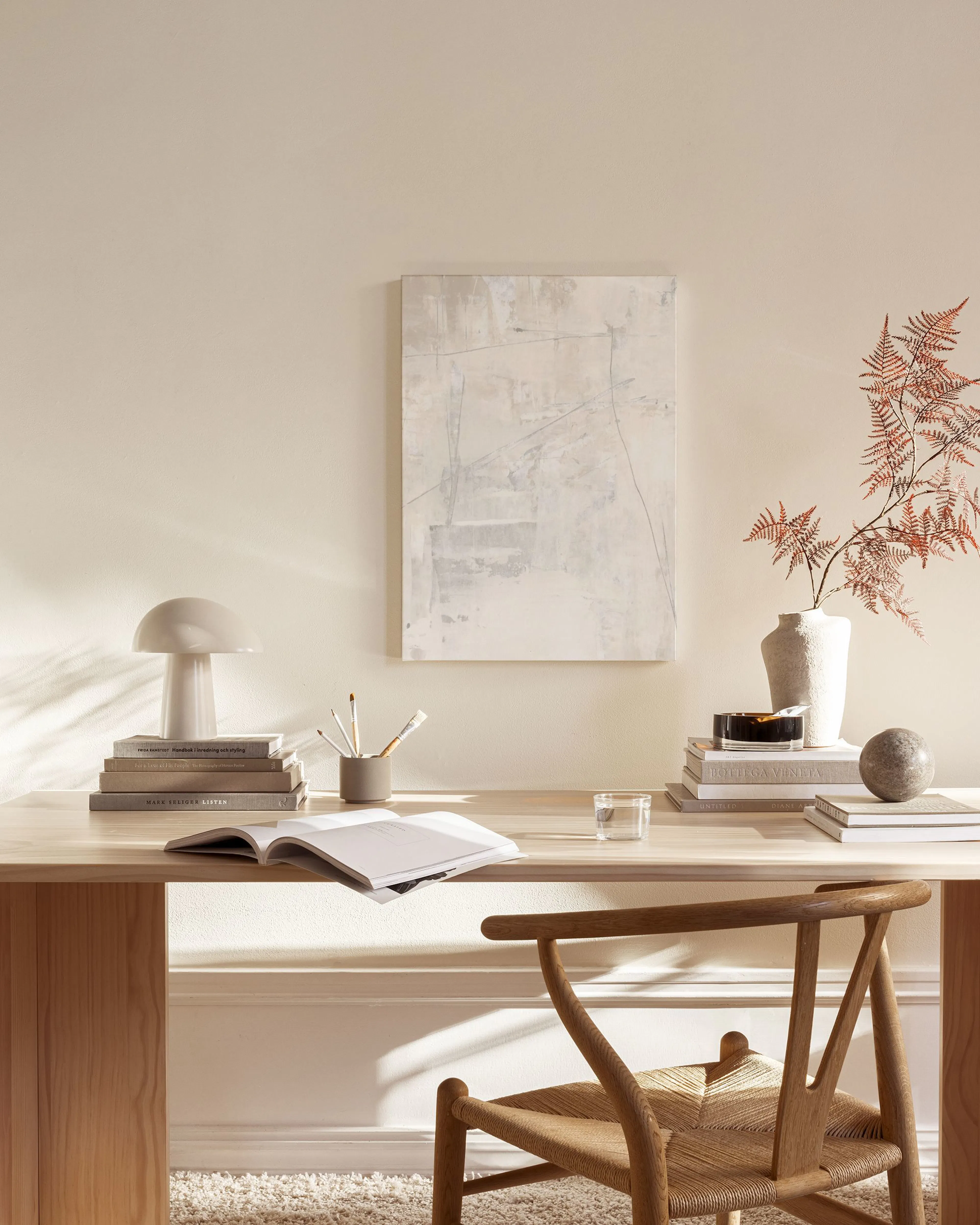 Toile abstraite crème et grise avec lignes fines, suspendue dans un salon moderne.