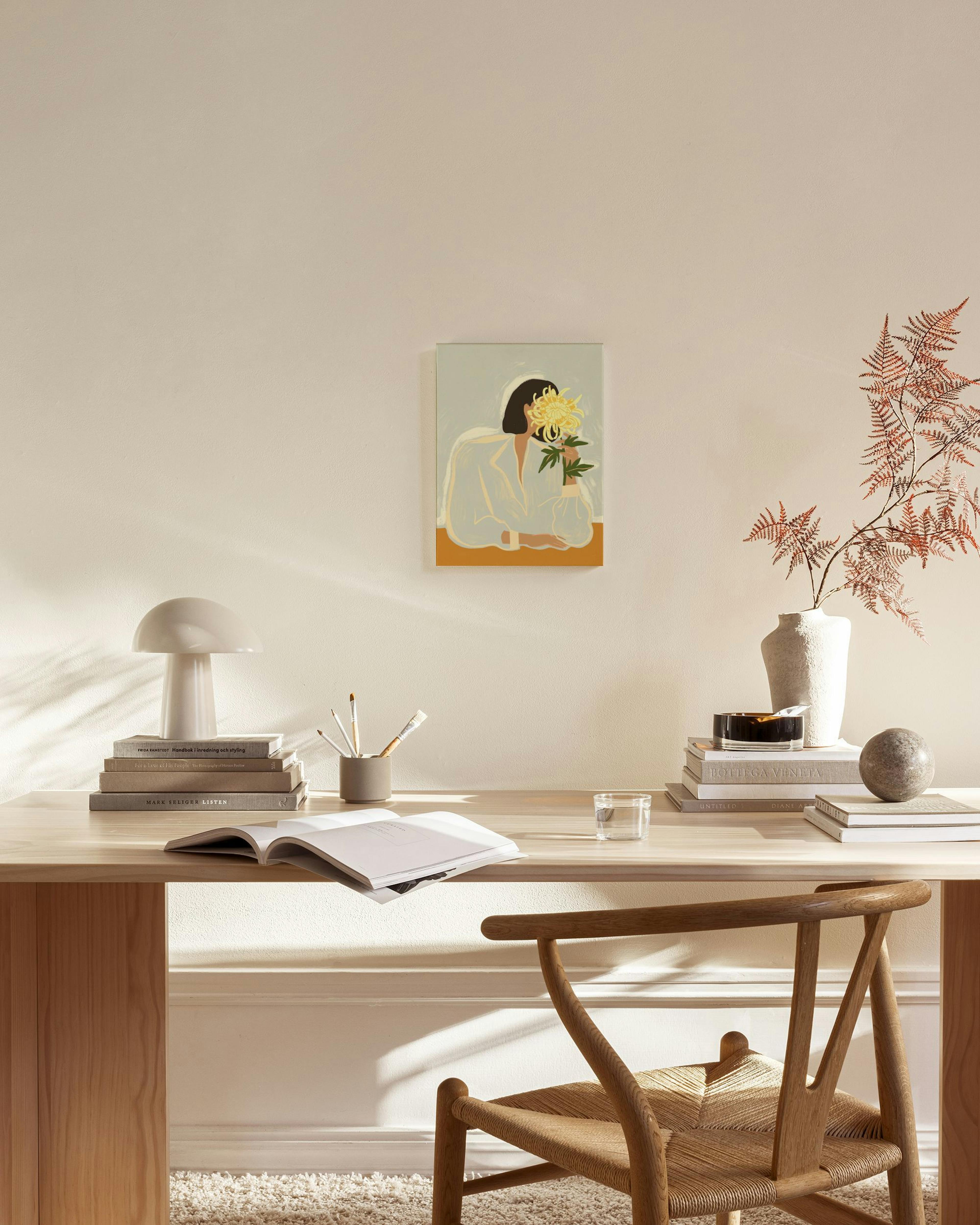 Canvas van een vrouw met donker haar die een boeket gele bloemen vasthoudt, hangend in een neutrale woonkamer.