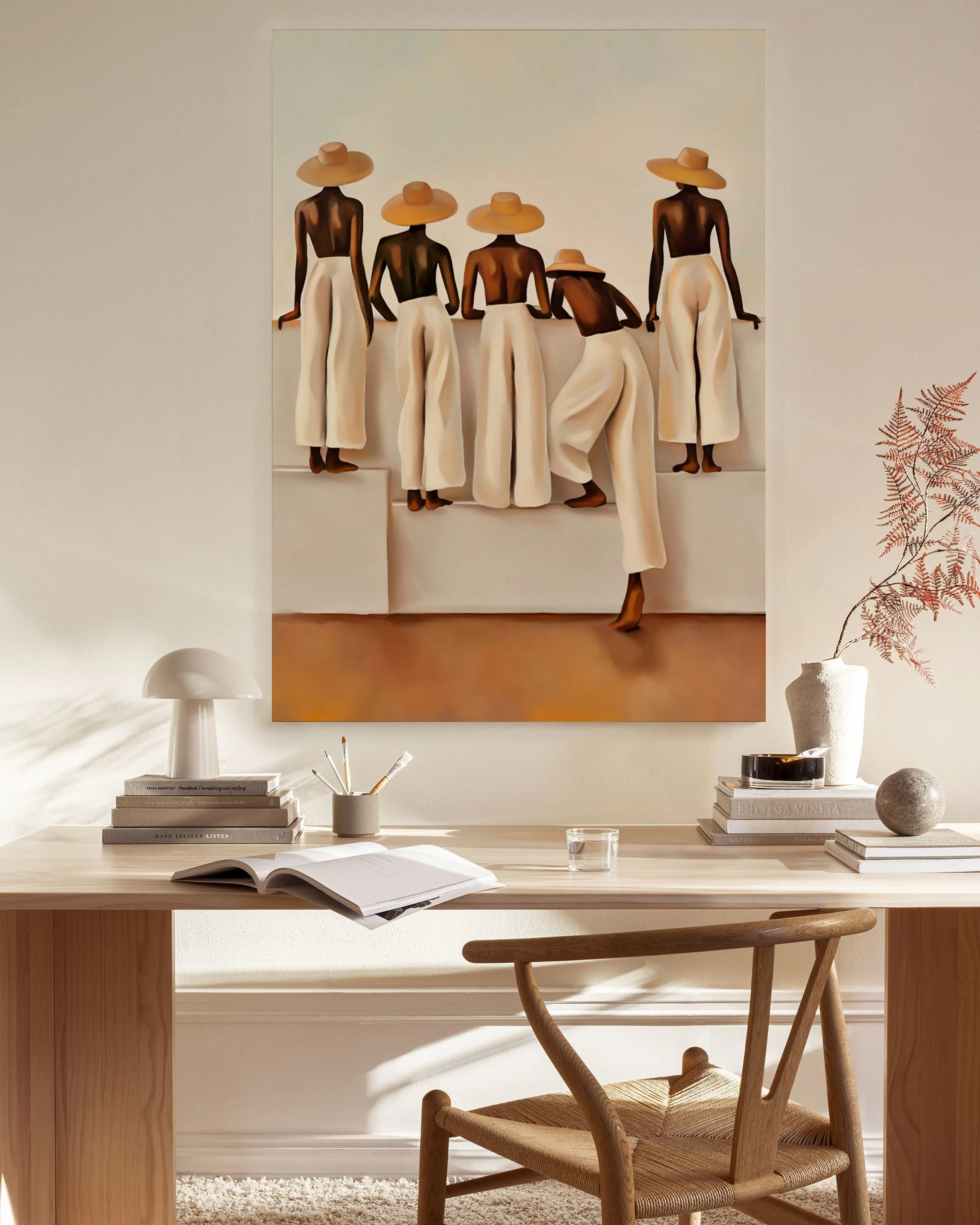A canvas print of five figures in straw hats and white pants, displayed in a bright, modern living room.