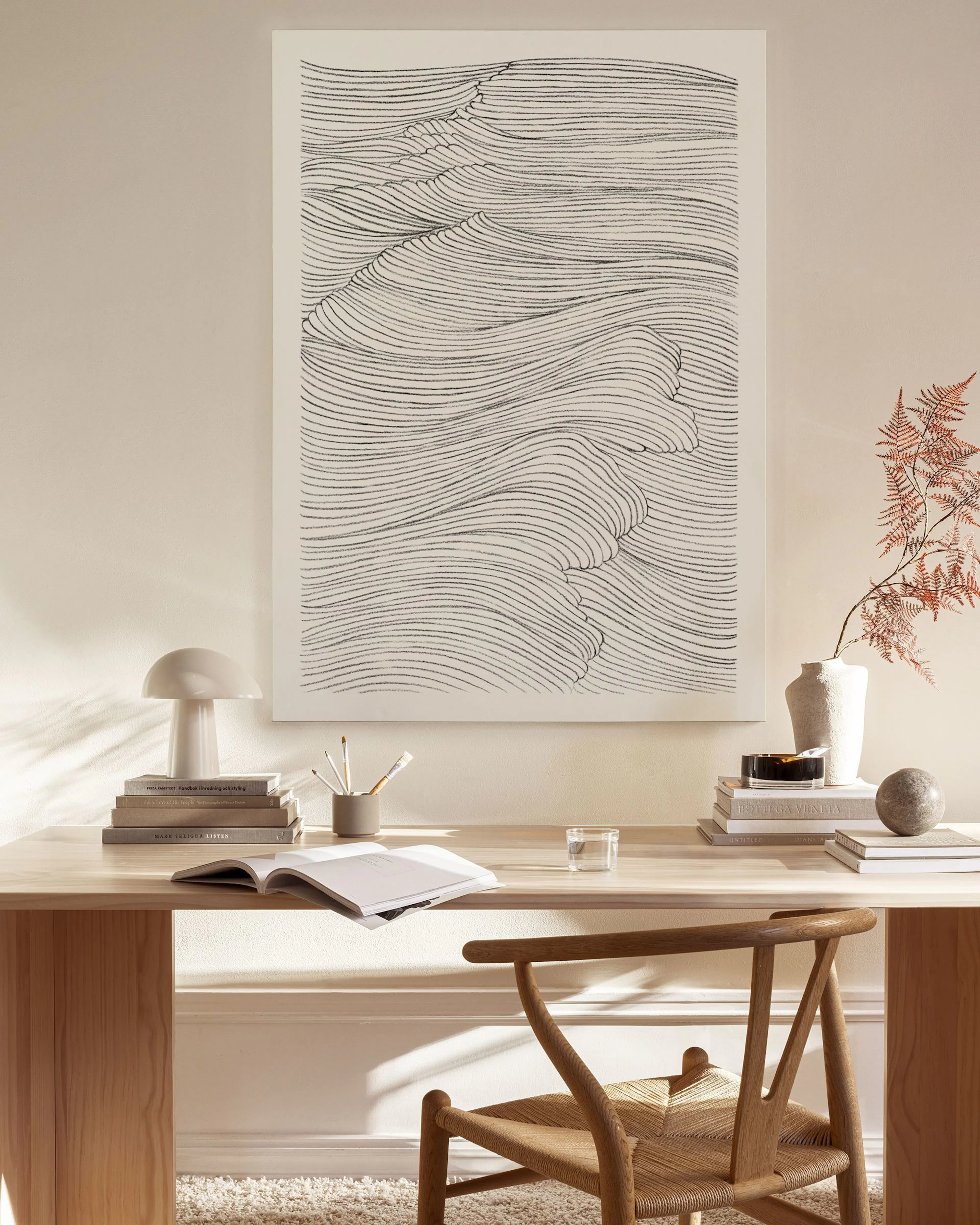Toile murale aux lignes noires ondulantes sur fond clair, accrochée au-dessus dun banc en bois dans un salon moderne.