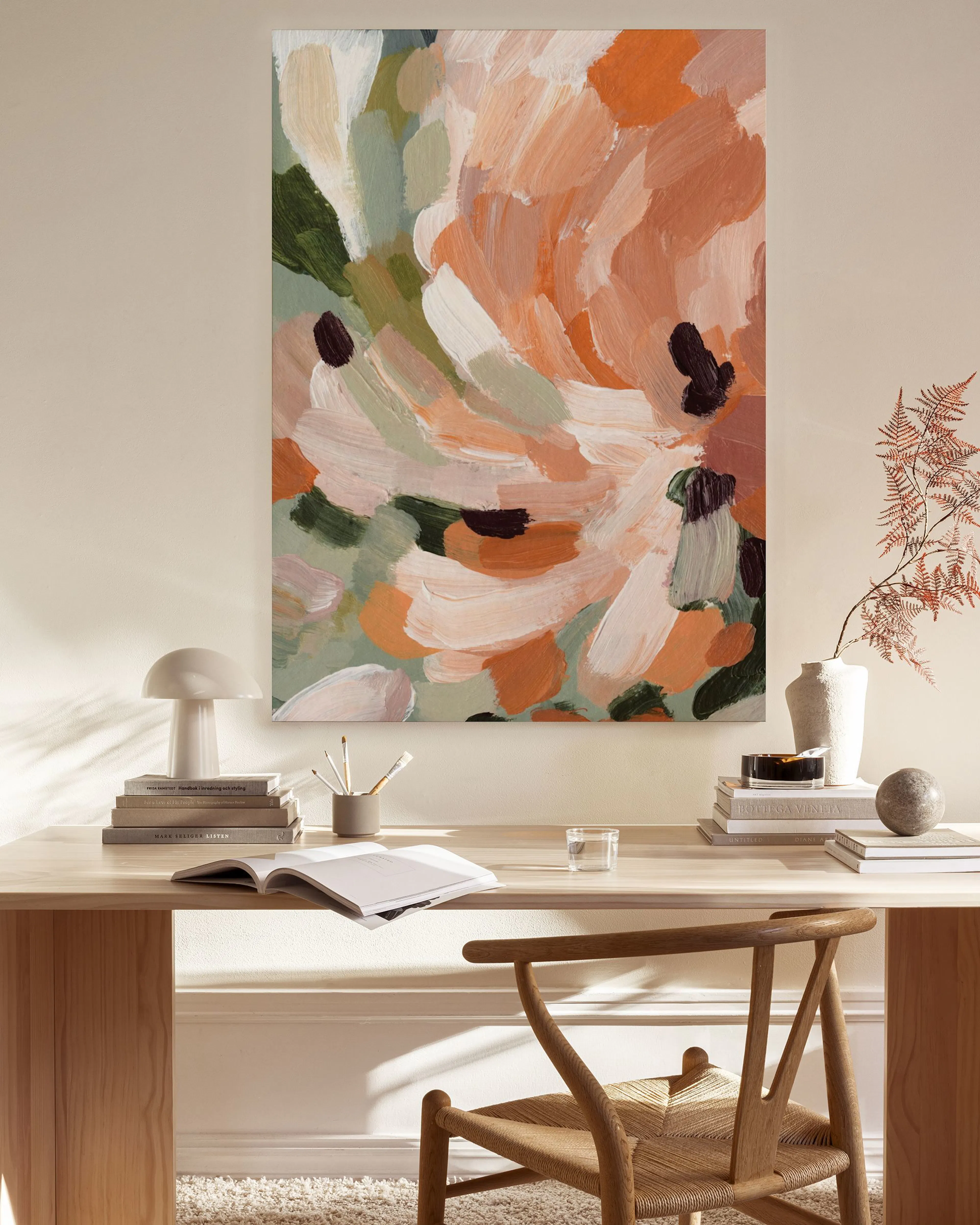 Tela decorativa abstrata com pinceladas em tons de pêssego, verde e branco, pendurada numa sala de estar com mobiliário de madei