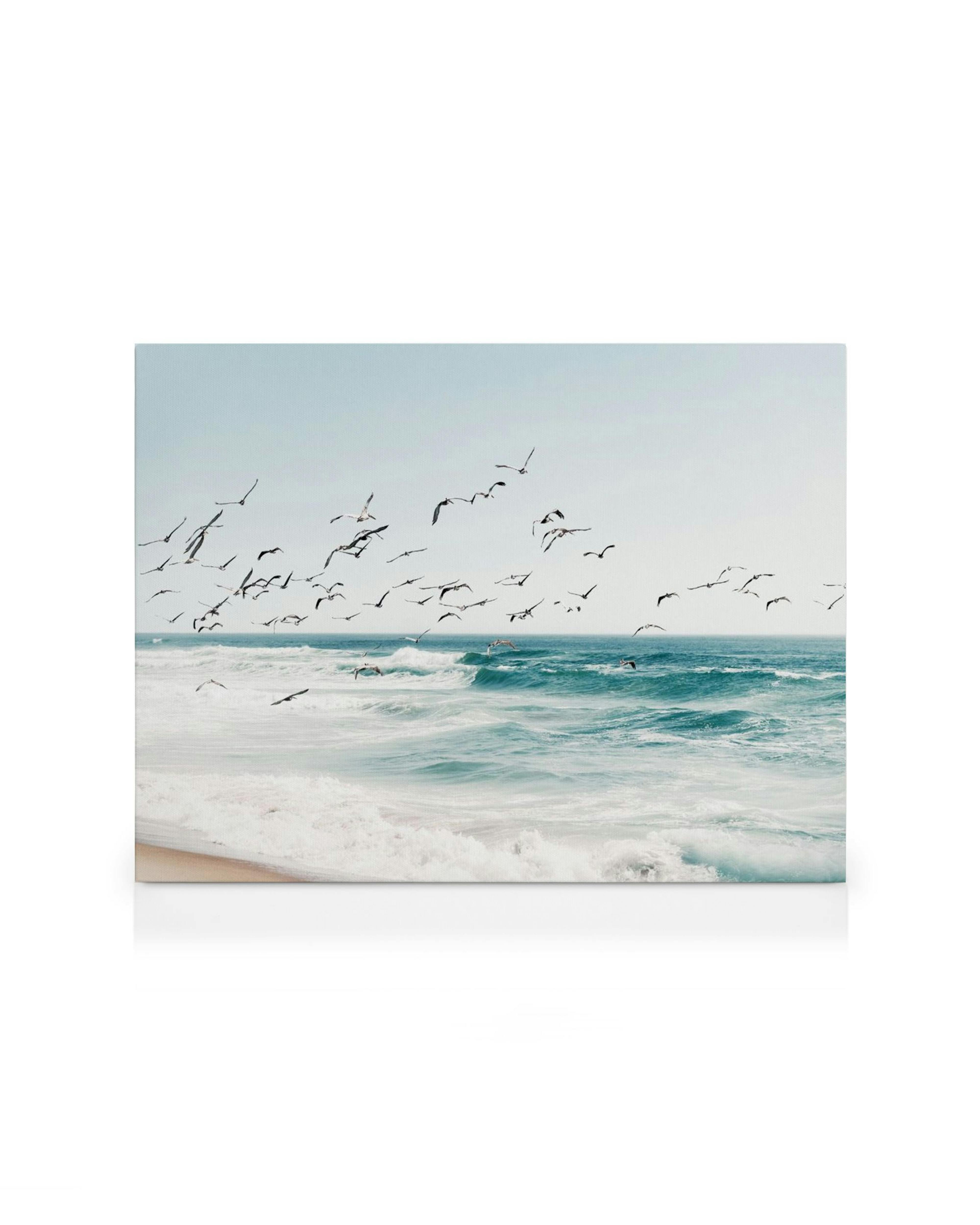Lienzo de aves volando sobre el mar turquesa con olas rompiendo en la playa de arena. Arte de paisaje marino sereno.