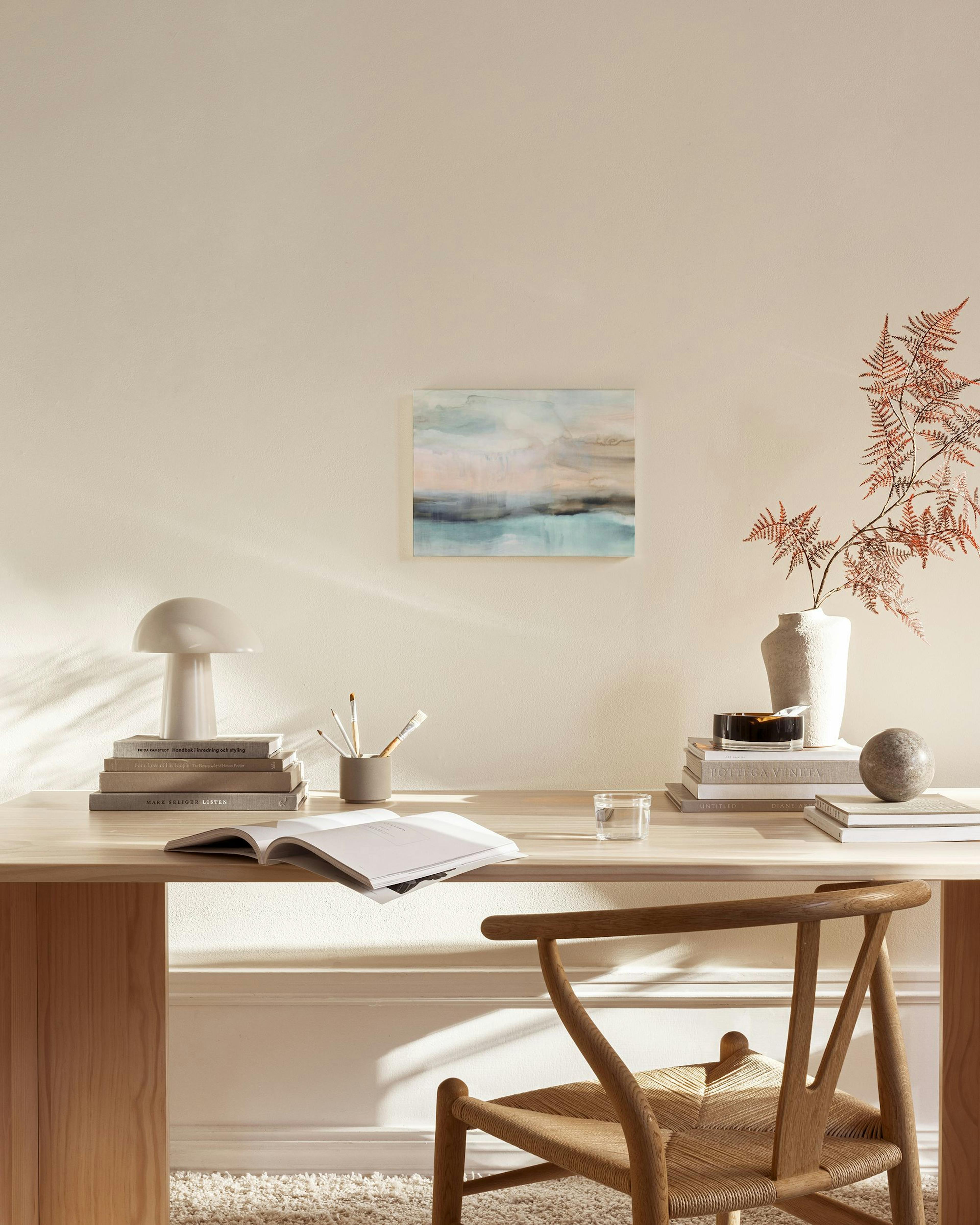 Abstraktes Landschafts-Leinwandbild in Blau, Beige und Grau über einem Sideboard in einem modernen Wohnzimmer.