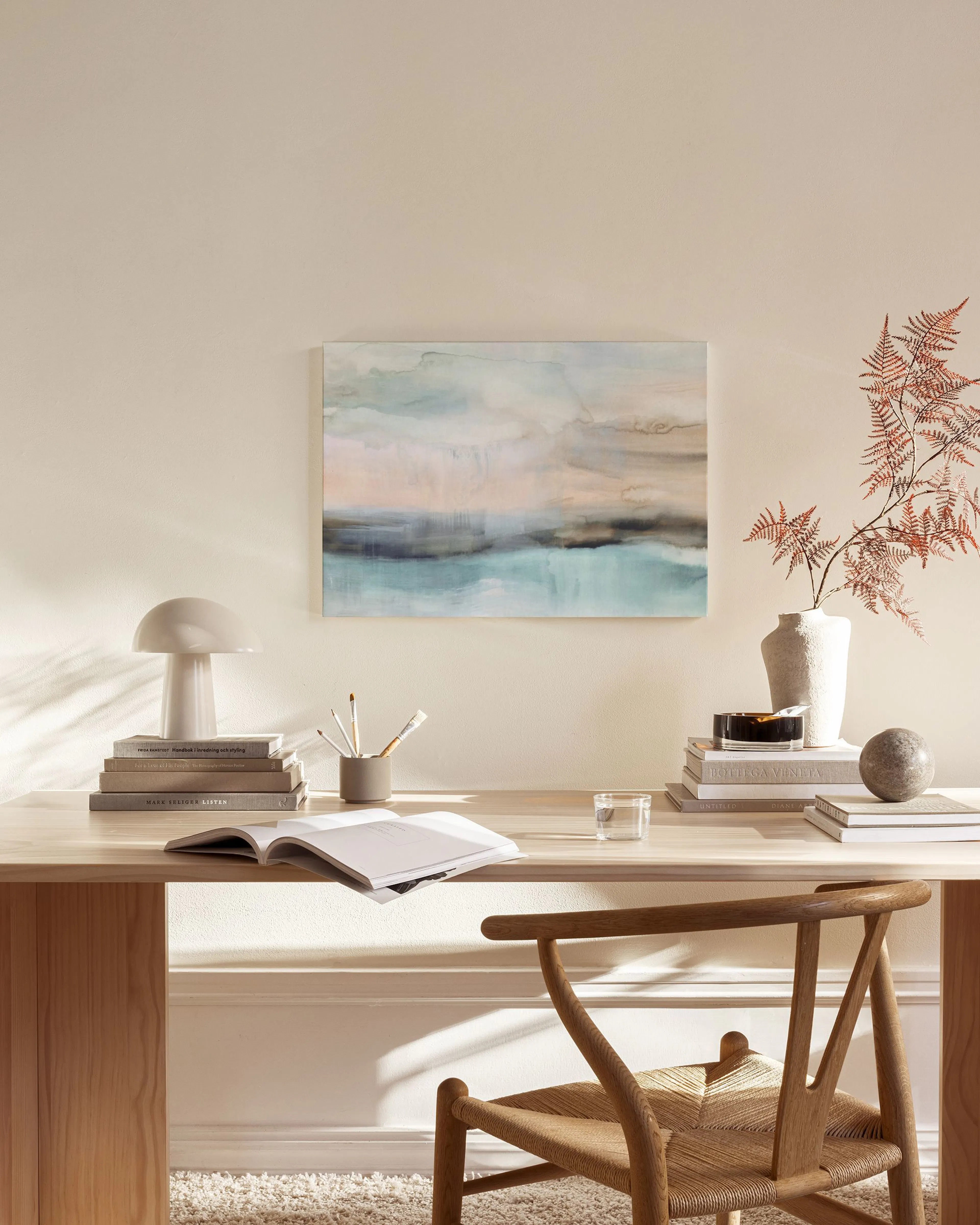 Toile abstraite aux tons bleus et beiges, suspendue au-dessus dun meuble bas dans un salon moderne.