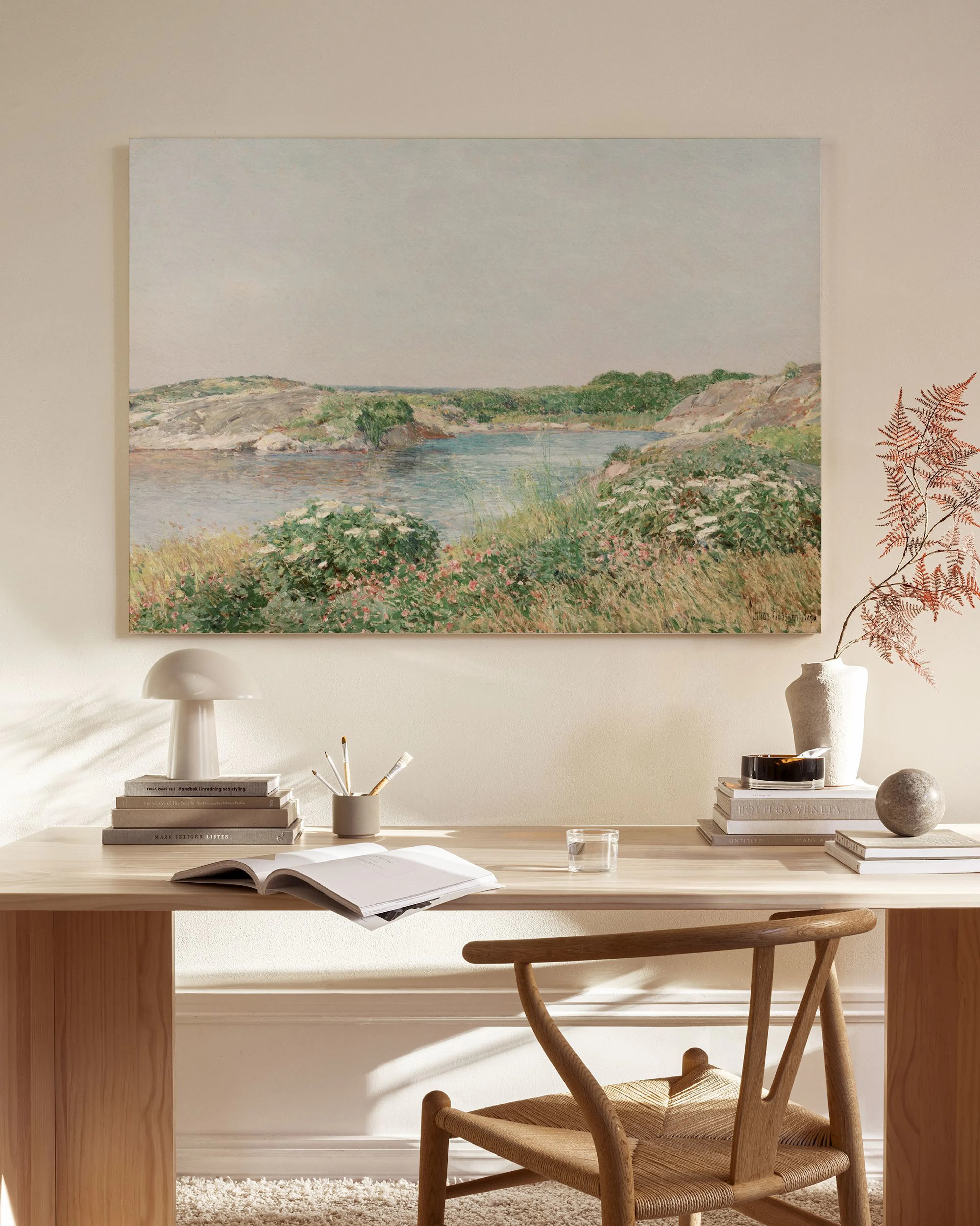 Impressionist landscape canvas print depicting a tranquil blue bay with rocky shores, green grasses, and white and pink wildflow