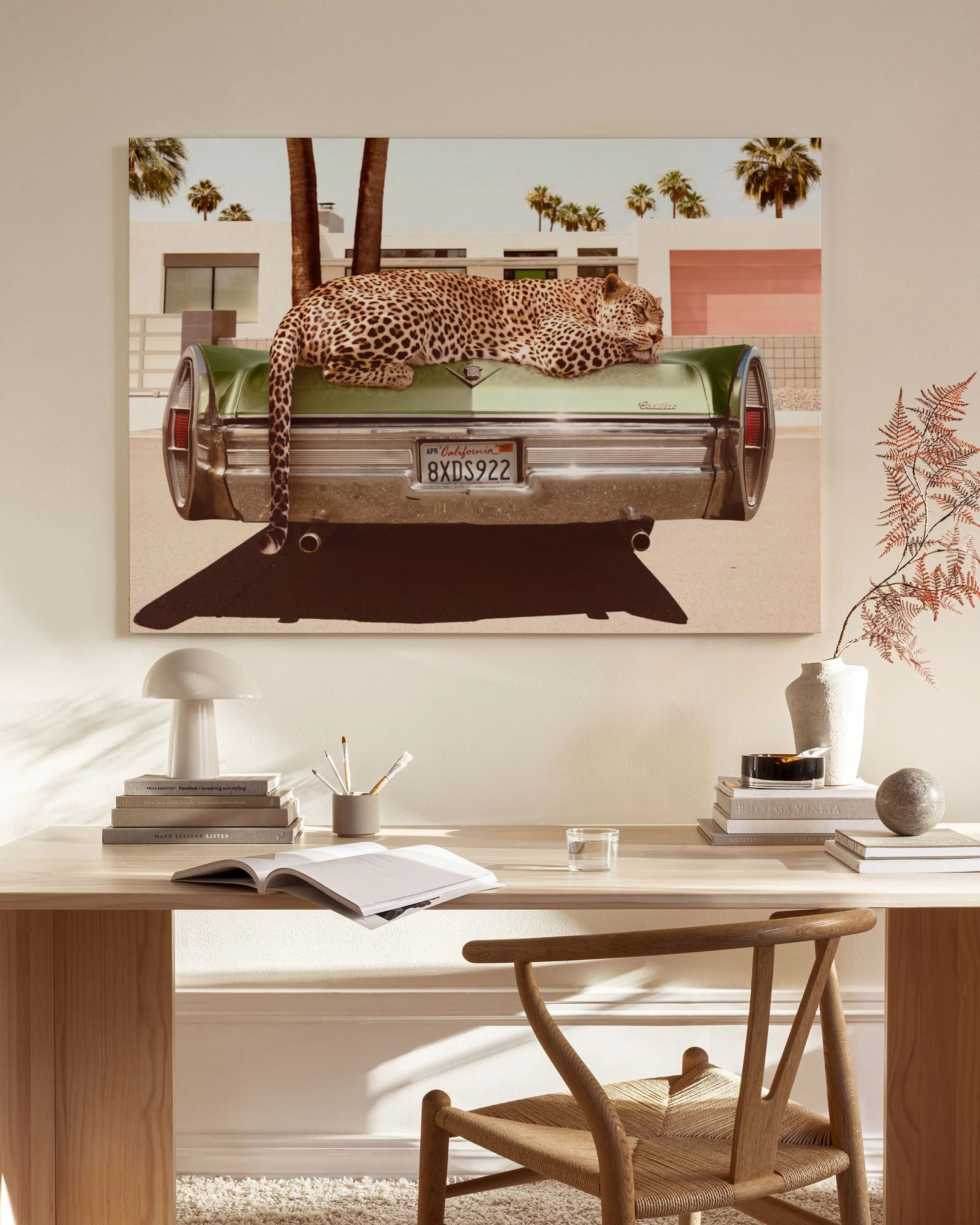 Toile dun léopard endormi sur une voiture verte avec des palmiers et un bâtiment blanc en arrière-plan, style Palm Springs.