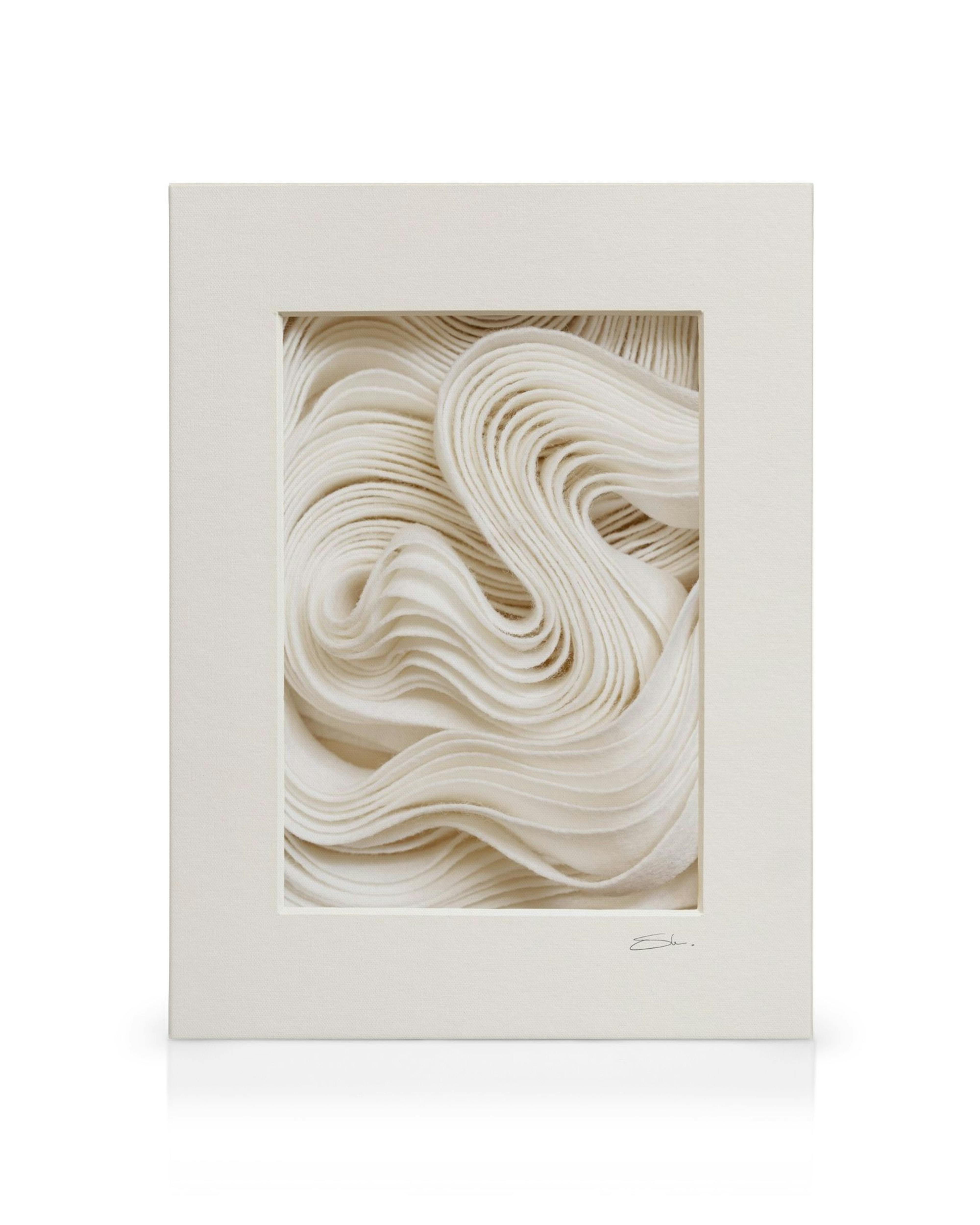 Stampa su tela con texture bianche fluide e ondulate, incorniciata con bordo beige e mat bianco.