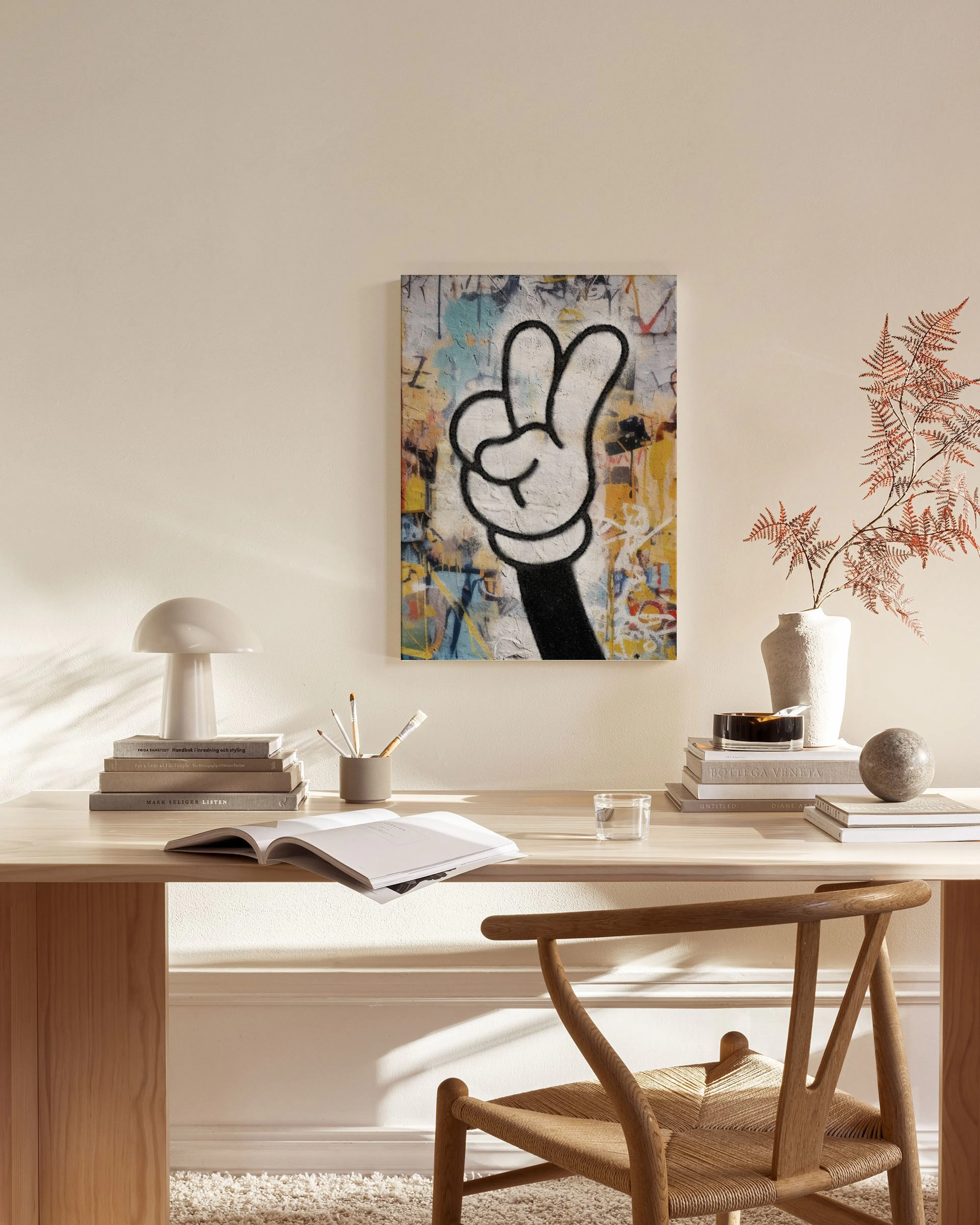 A canvas print of a cartoon hand making a peace sign on a colourful abstract background, hanging in a modern living room.