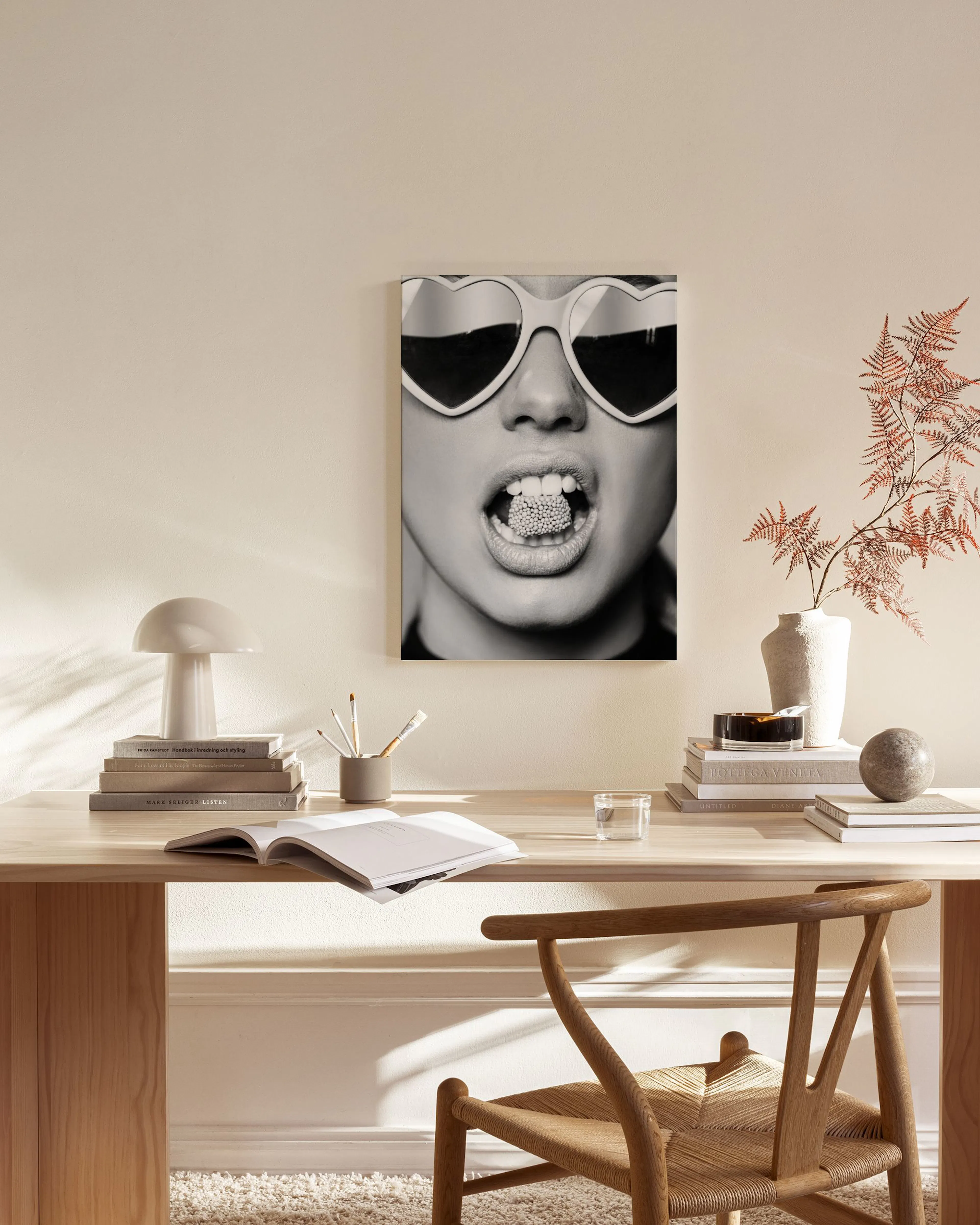 Schwarz-weiß Leinwandbild einer Frau mit Herzsonnenbrille und glitzerndem Mund, hängend in einem hellen Wohnzimmer.