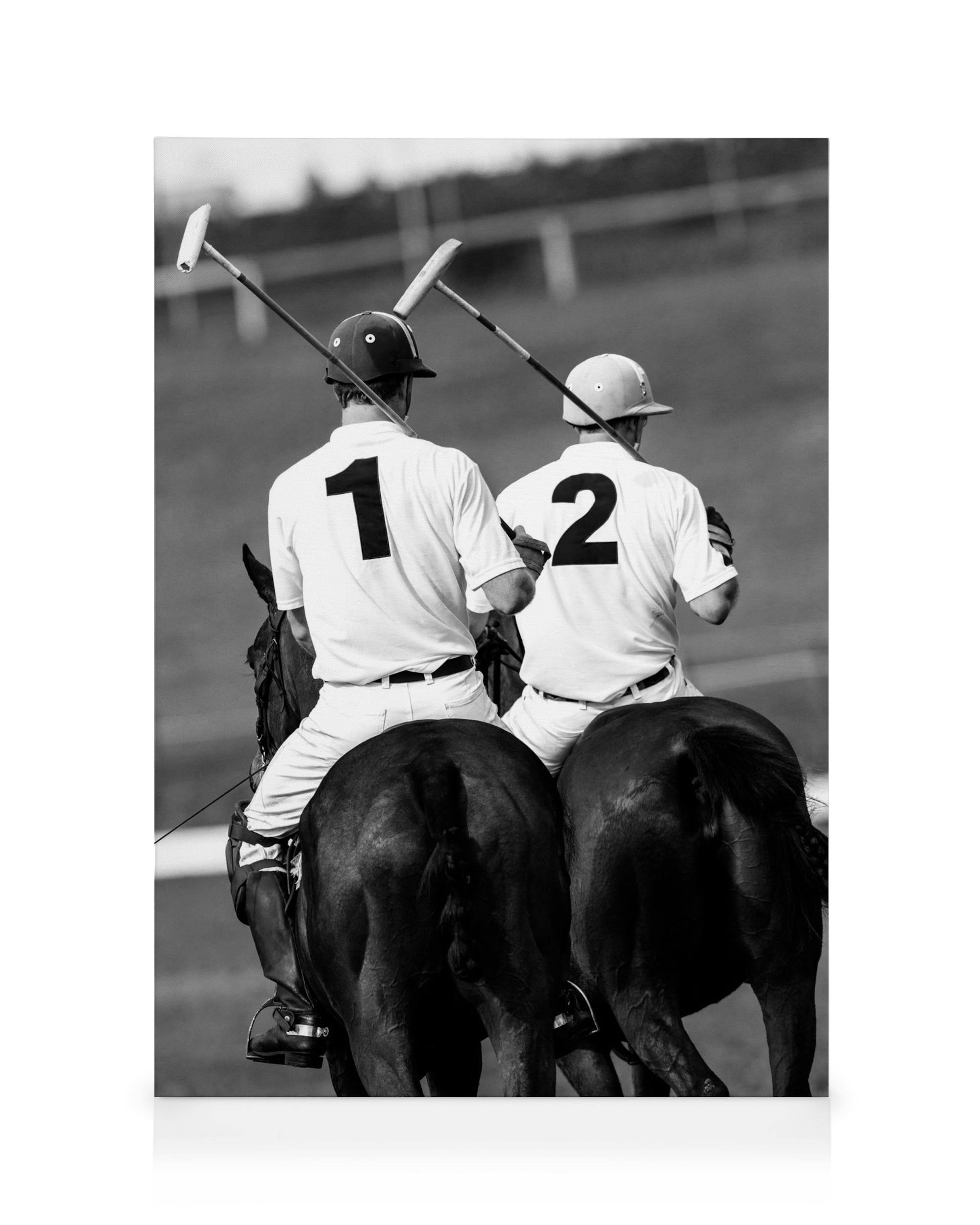 Black and white canvas print of two polo players on horseback with mallets, seen from behind.