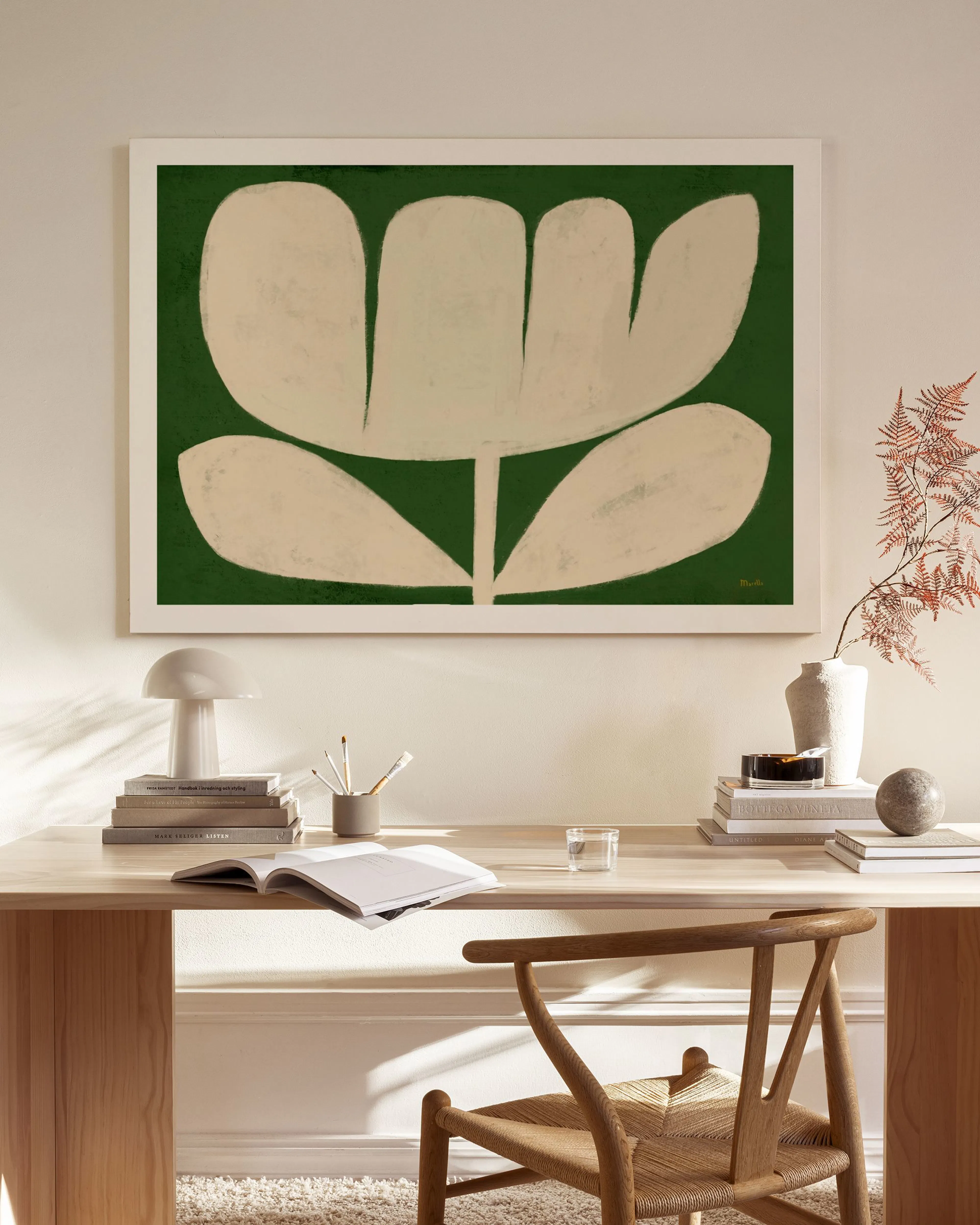 Beige kukka abstraktilla vihreällä taustalla, ripustettuna moderniin olohuoneeseen.