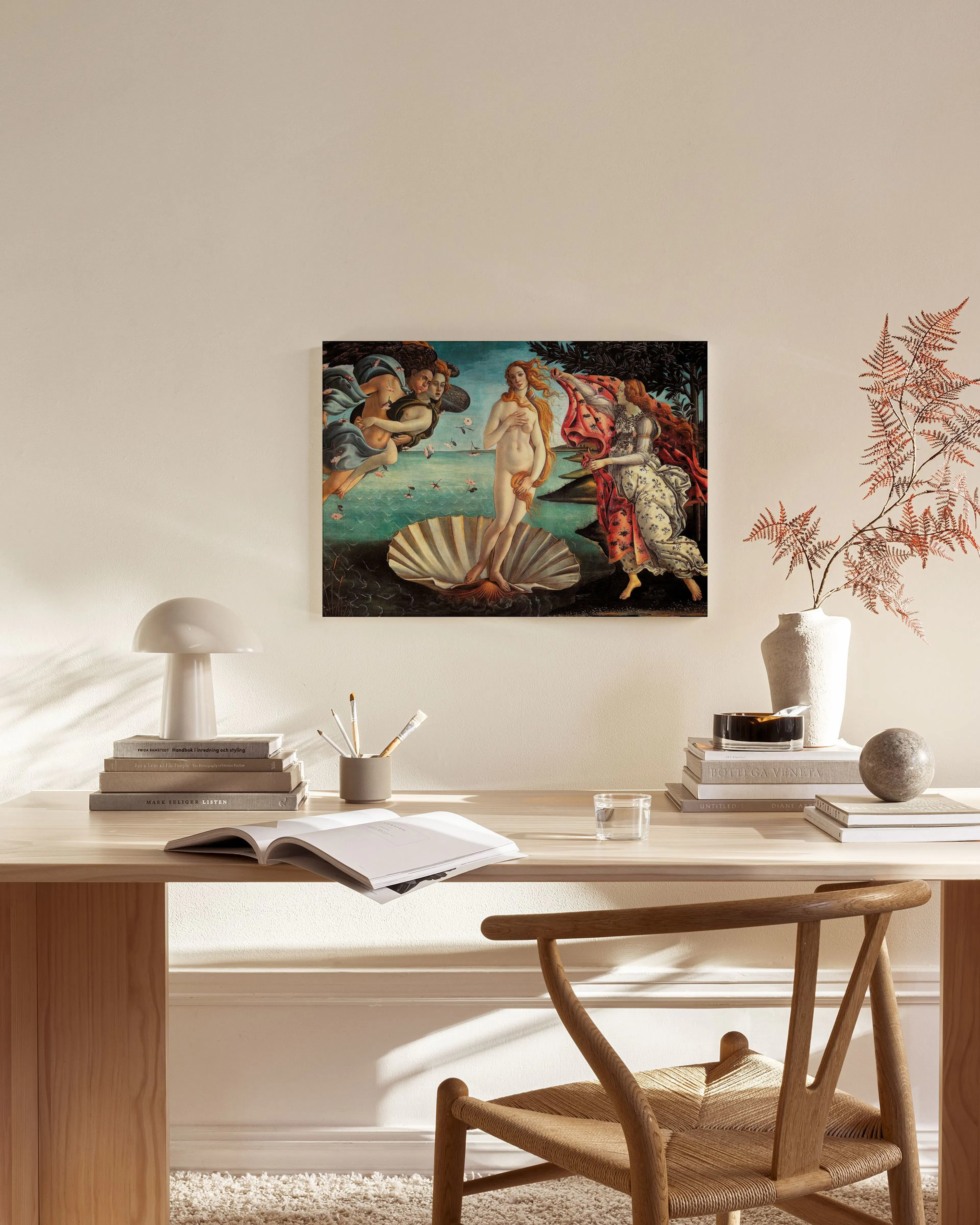 Toile La Naissance de Vénus de Botticelli, suspendue dans un salon moderne au-dessus dune commode en bois clair.