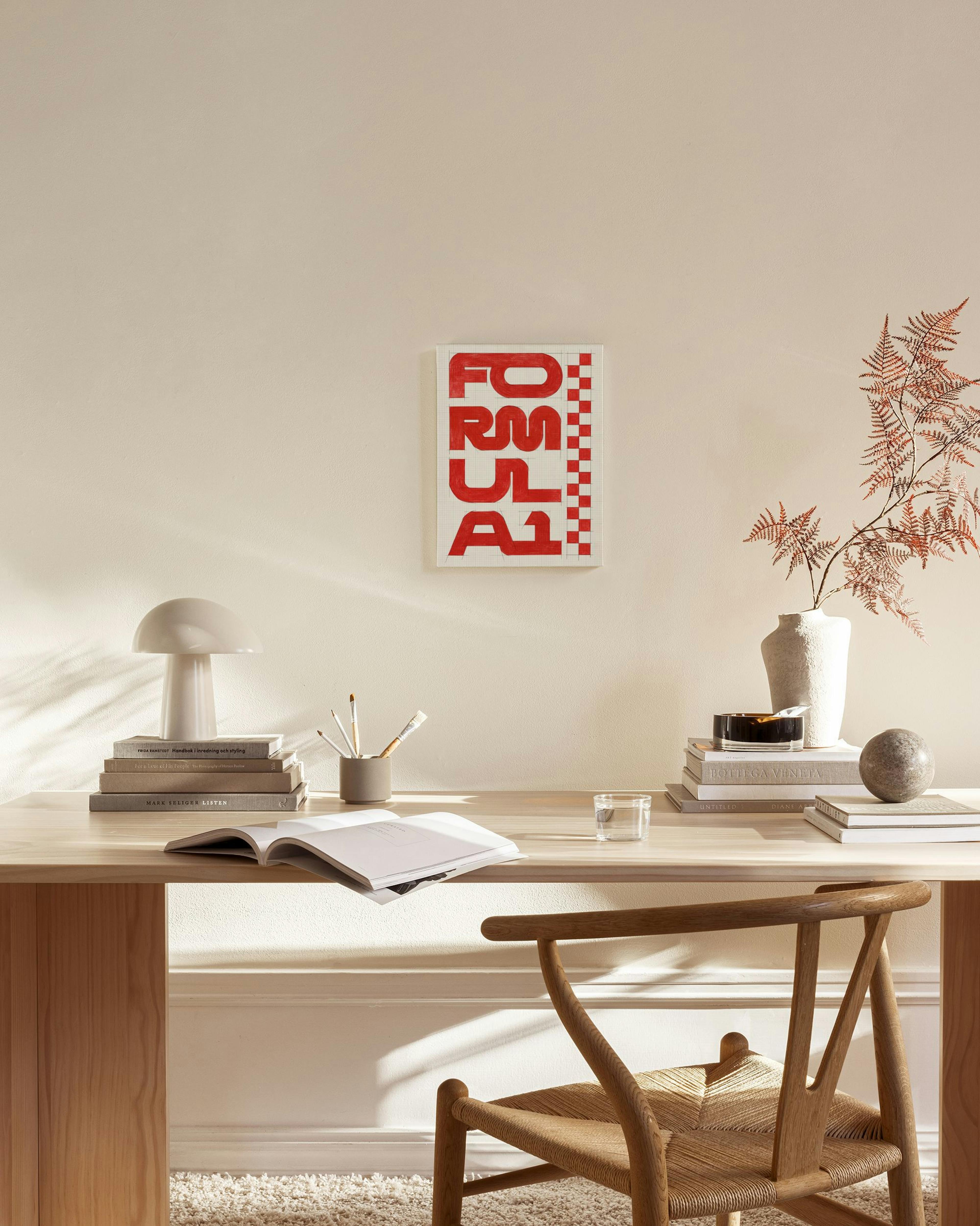 Obraz na płótnie z czerwonym napisem FORMULA 1” i szachownicą, zawieszony w nowoczesnym salonie obok drewnianego fotela.