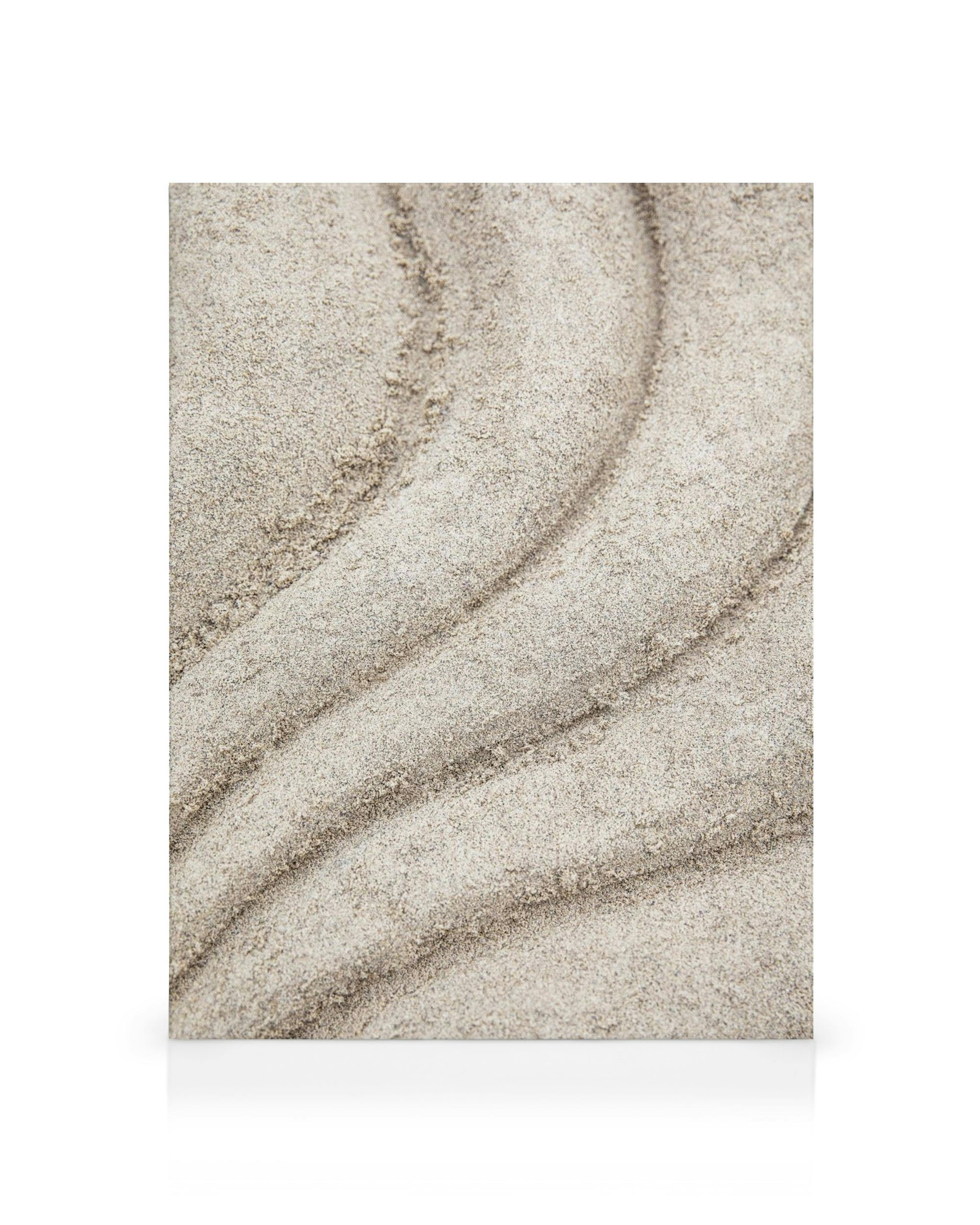 Lienzo con líneas onduladas de arena marrón claro y granulada sobre un fondo blanco, creando un patrón abstracto.