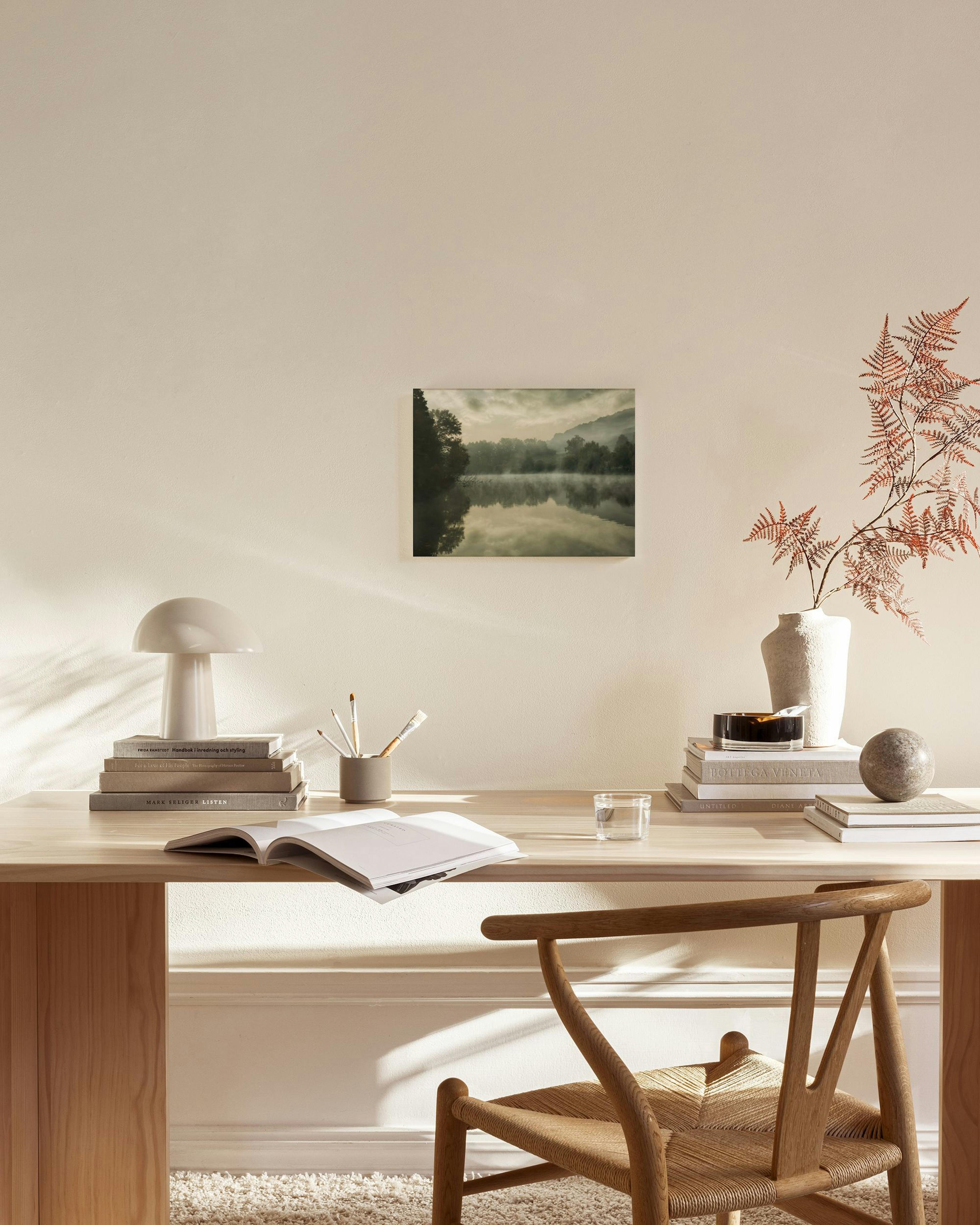 Leinwandbild einer nebligen Flusslandschaft mit Wald und Bergen, hängend über einem Sideboard im Wohnzimmer.