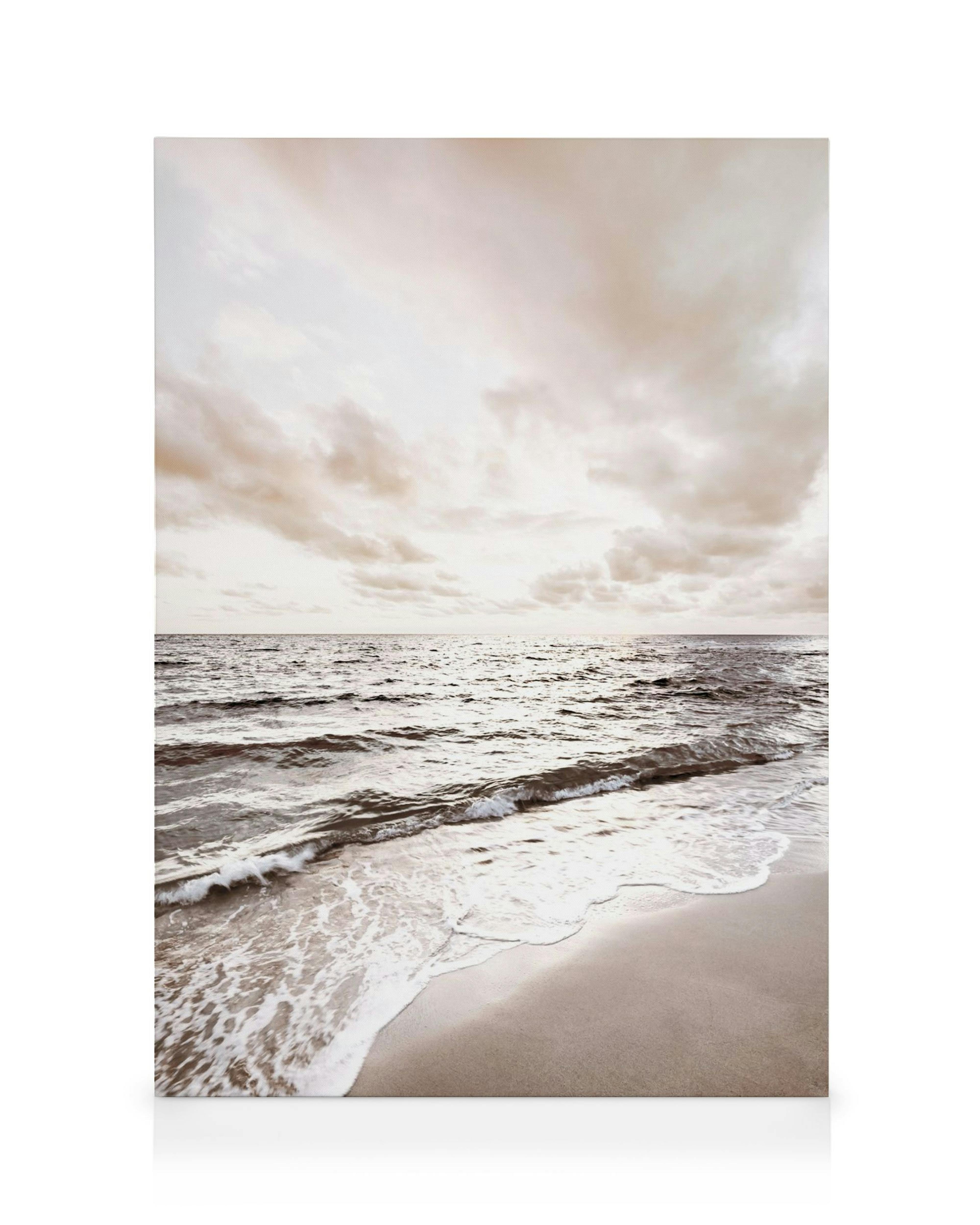 Strand canvas met zachte golven op zand, serene blauwe en bruine tinten onder een bewolkte hemel.