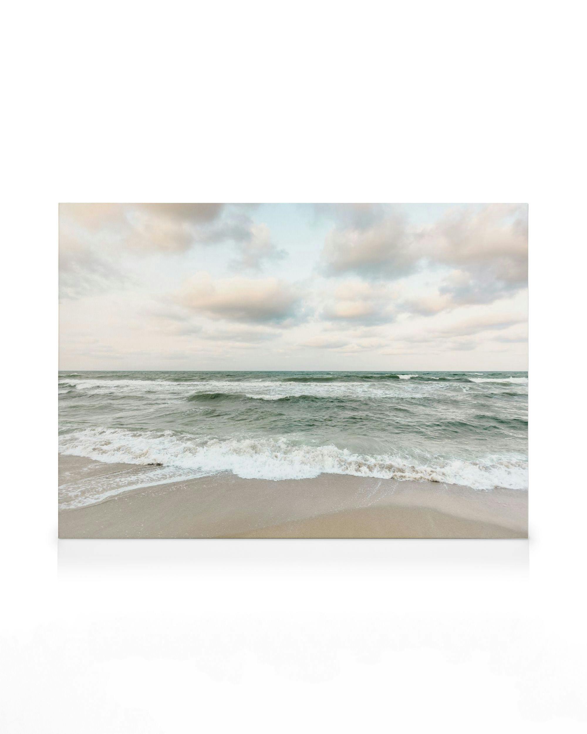 Stampa su tela di onde verde giada che si infrangono su una spiaggia sabbiosa, cielo nuvoloso beige pallido sullo sfondo.