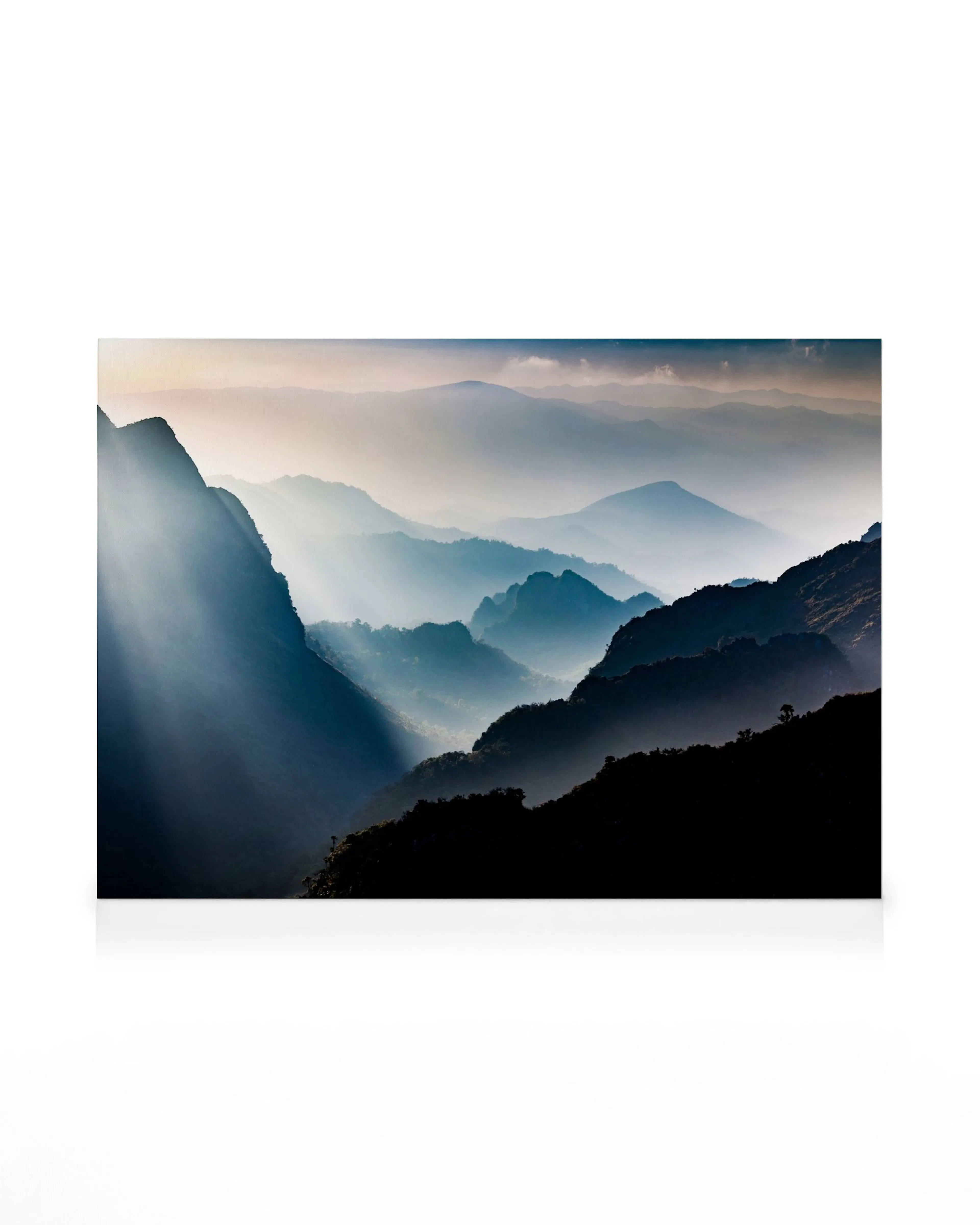 Canvas met mistige berglandschap, zonnestralen door nevel, donkere voorgrond, lichte lucht, natuurkunst.