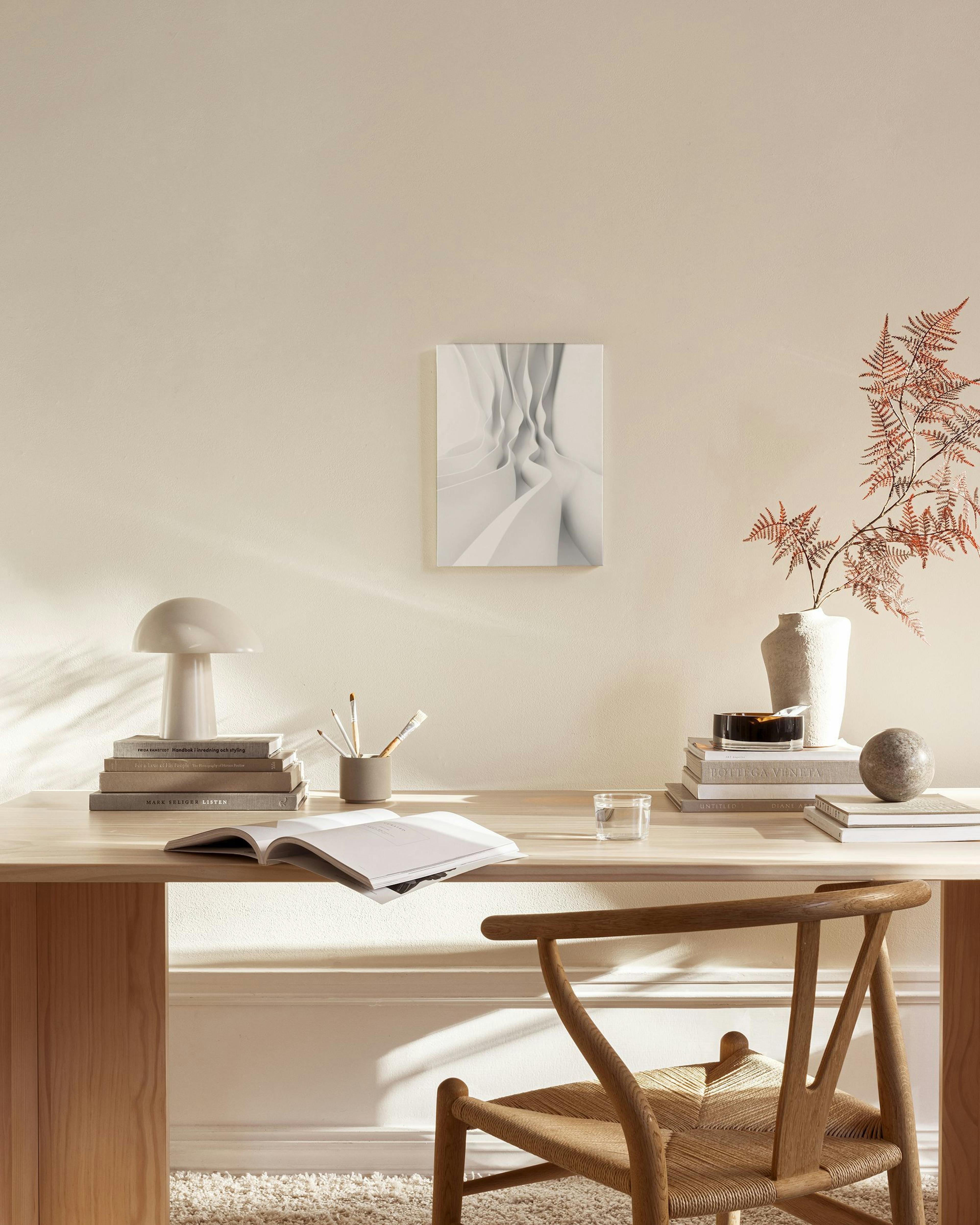 White abstract canvas print with flowing, curved forms, hanging above a wooden console table in a minimalist living room.