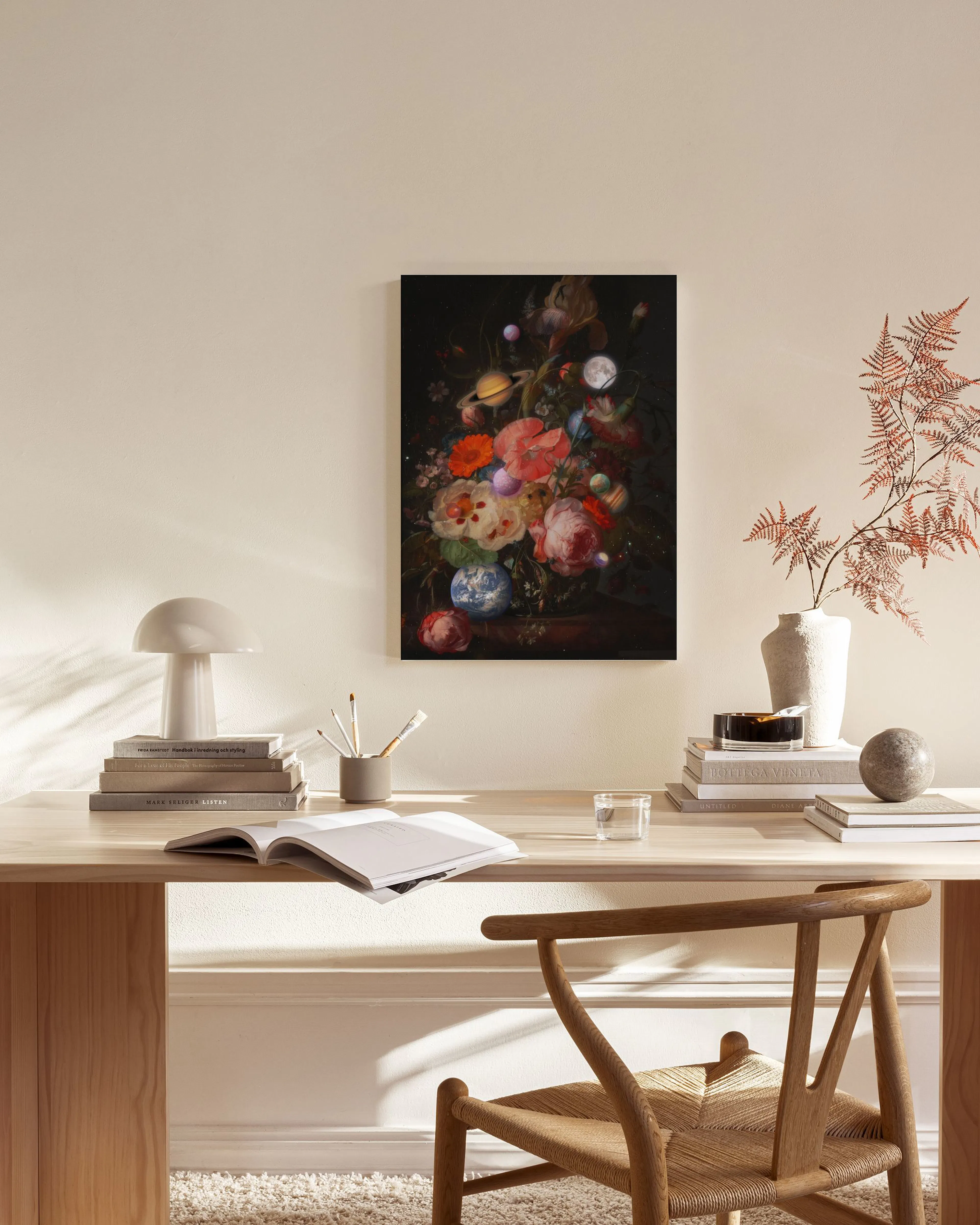 Lerretsbilde med blomster og planeter henger over en benk i et lyst, moderne rom.