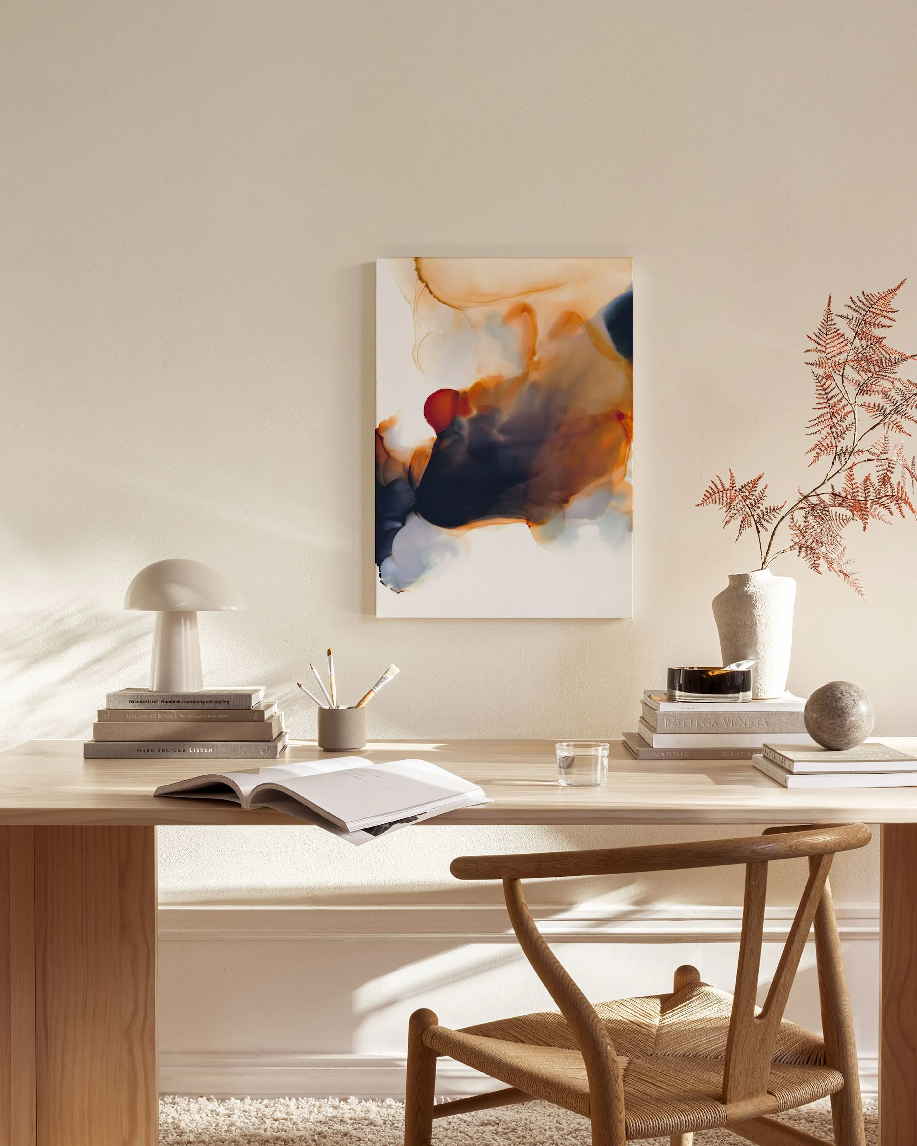 Abstract canvas print with red, orange, and blue organic shapes, hanging above a light wood bench in a modern living room.