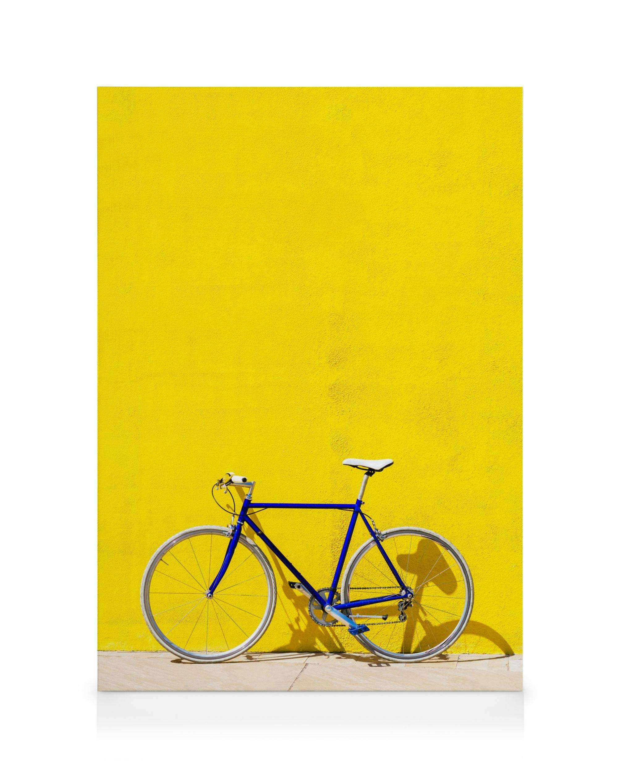 Blaues Fahrrad vor leuchtend gelber Wand, minimalistisches Design, klares Leinwandbild, modernes Wandbild