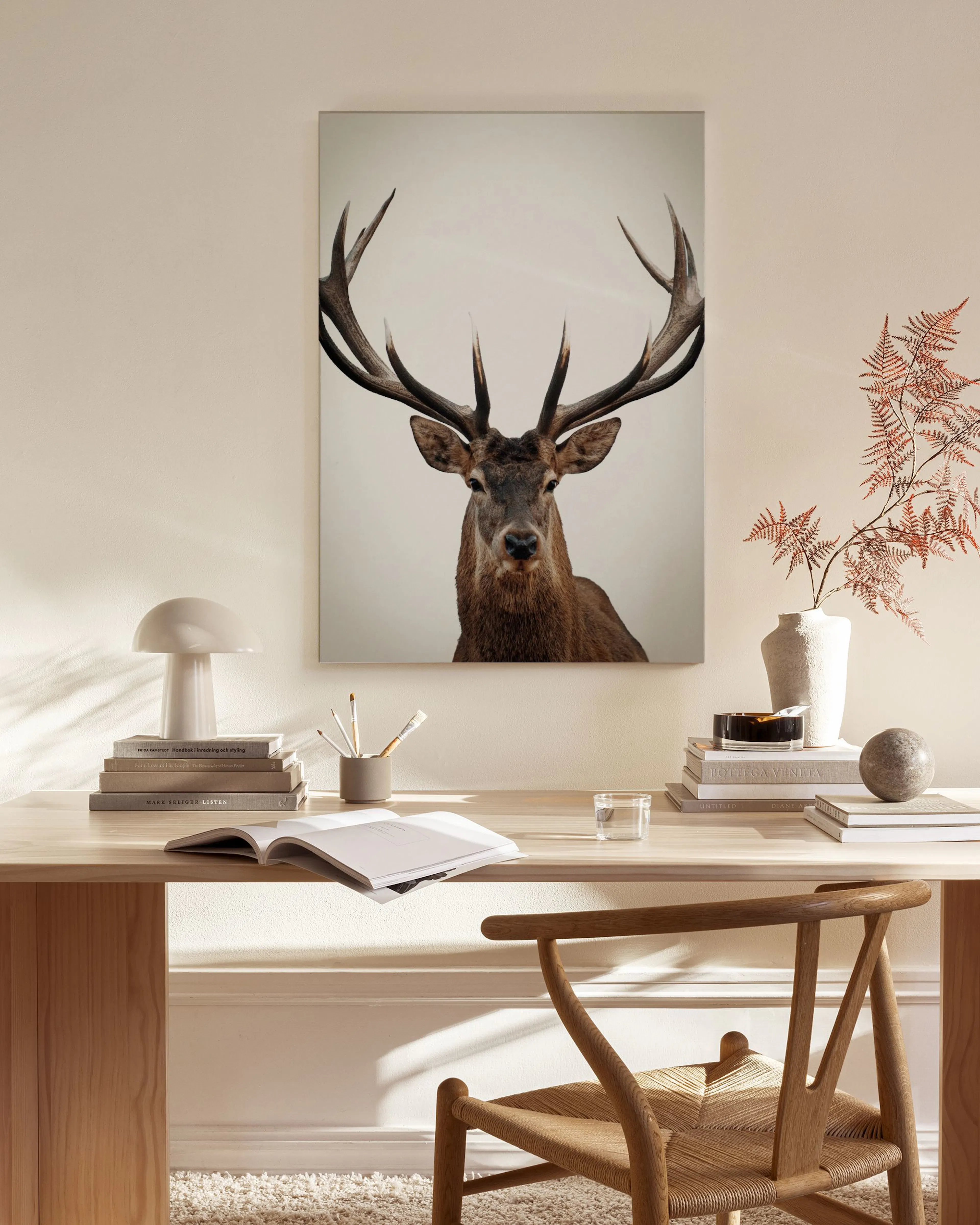A canvas print of a majestic stag with large antlers, displayed in a bright, modern living room.