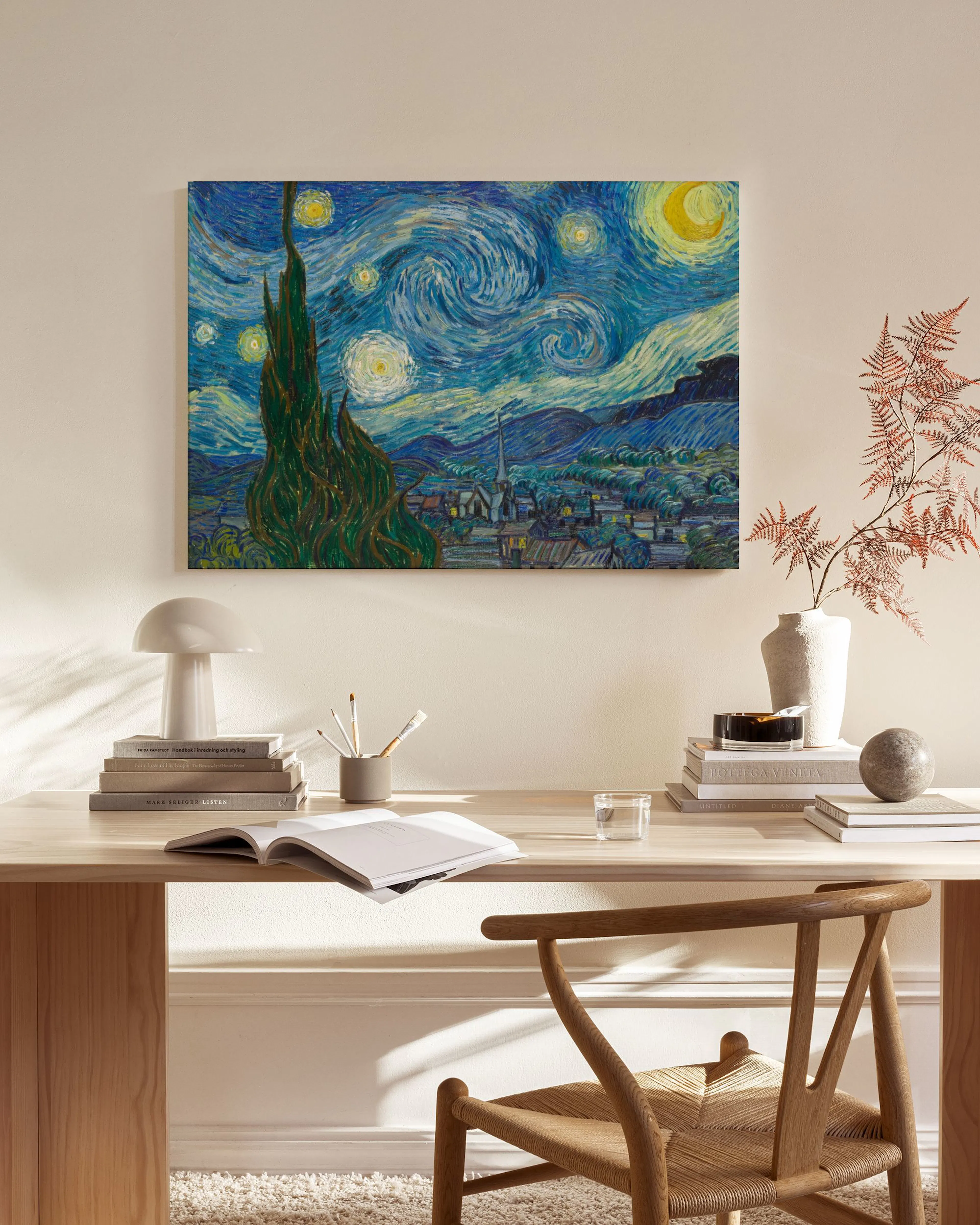 Van Goghs The Starry Night canvas print, with its famous cypress tree and swirling sky, displayed above a wooden console in a br