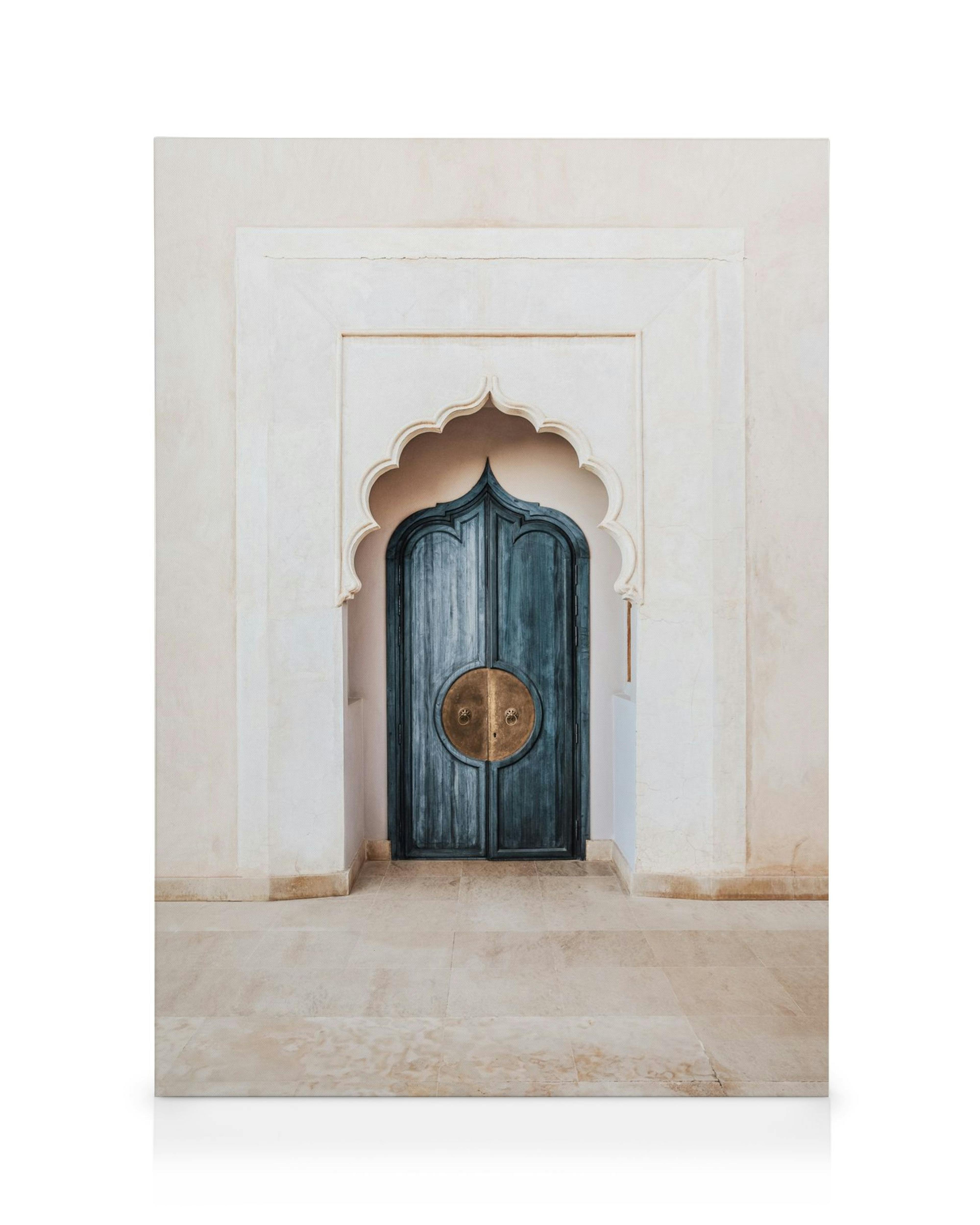 Marrakech Blue Door canvas print, featuring a rustic blue wooden door with ornate brass handles in a cream archway.