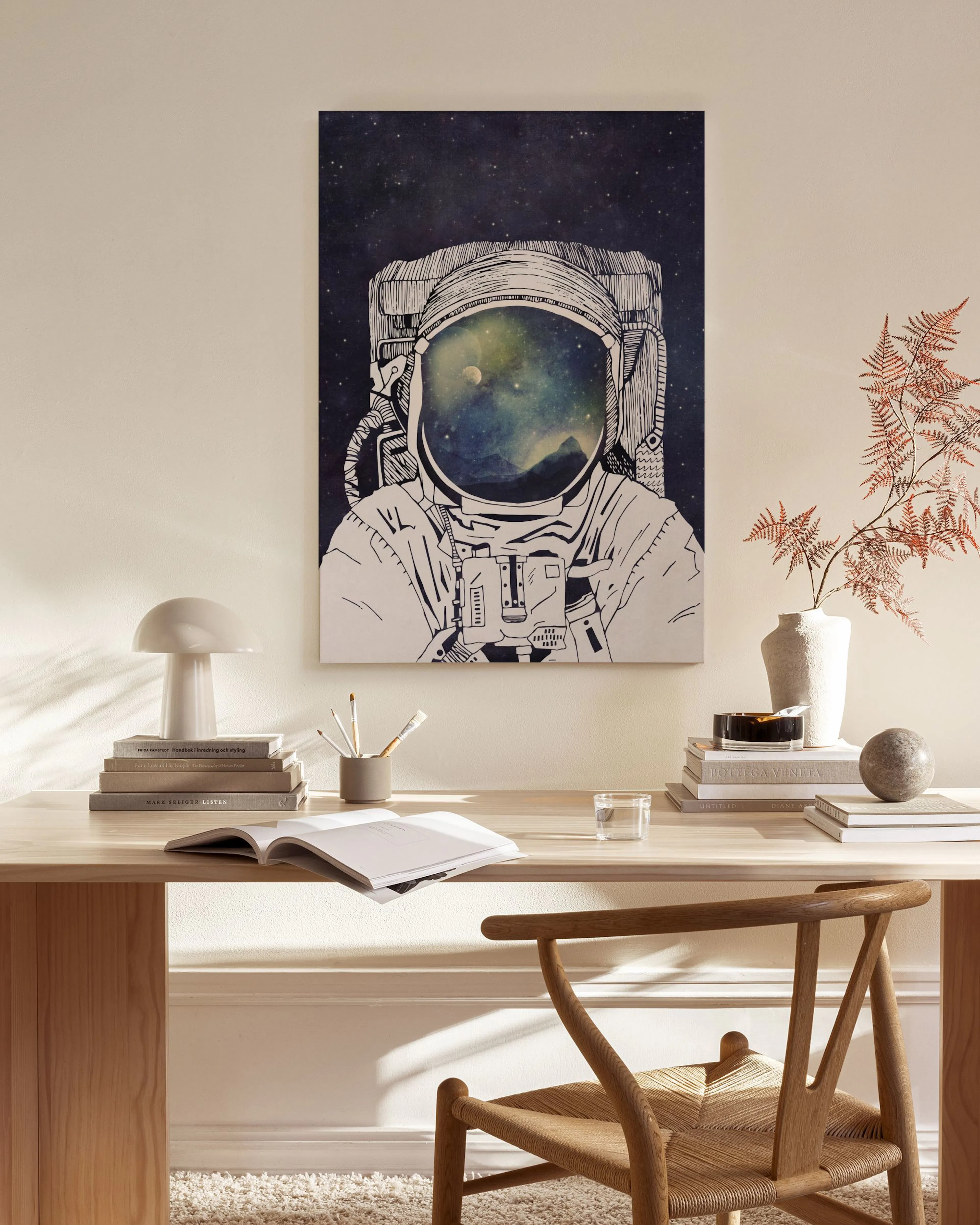 Lærred af en astronautdragt med galakse i hjelmen, hængende i et moderne minimalistisk rum.