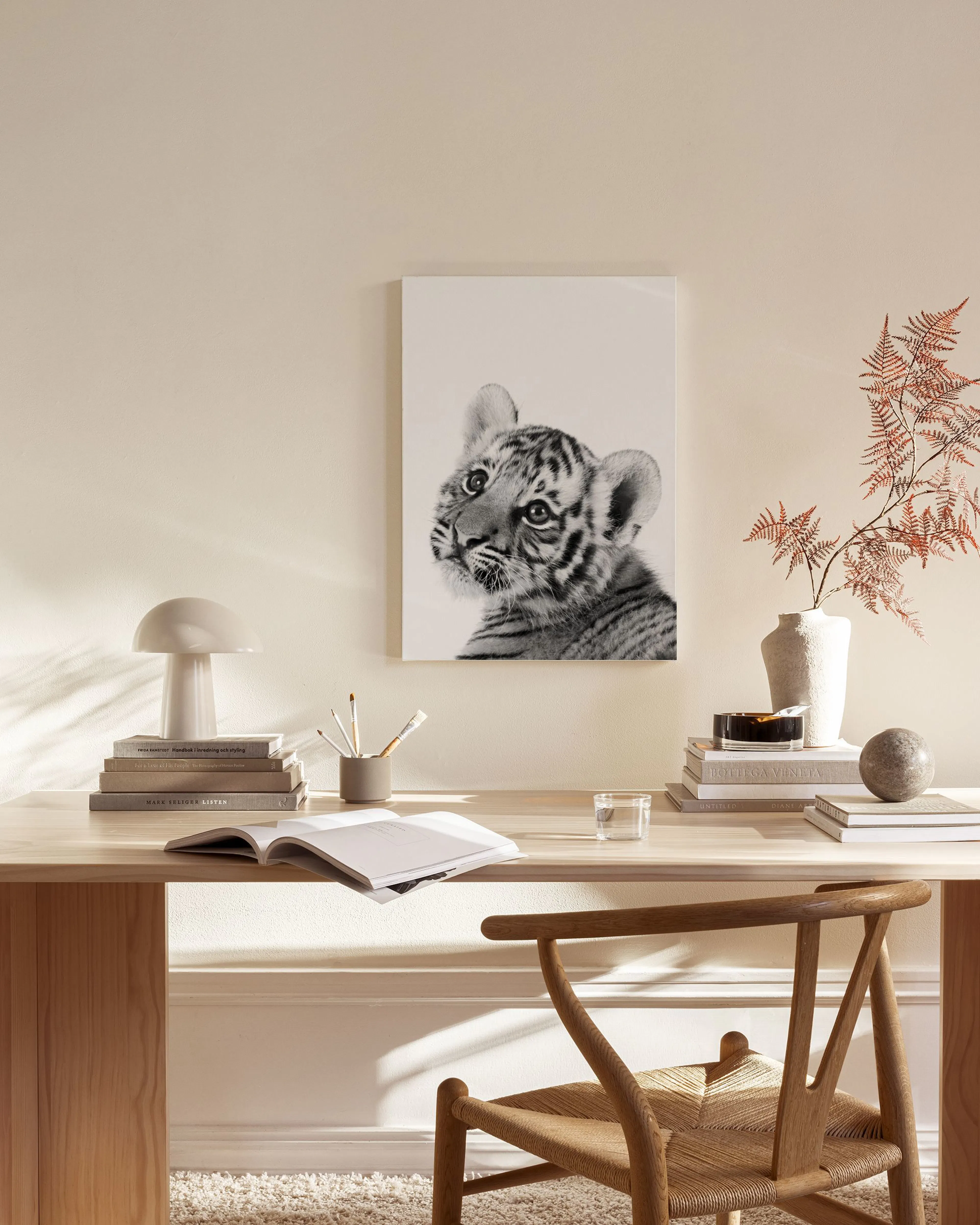 Lienzo de un bebé tigre en blanco y negro, decorando una sala de estar moderna con mesa de centro y silla.
