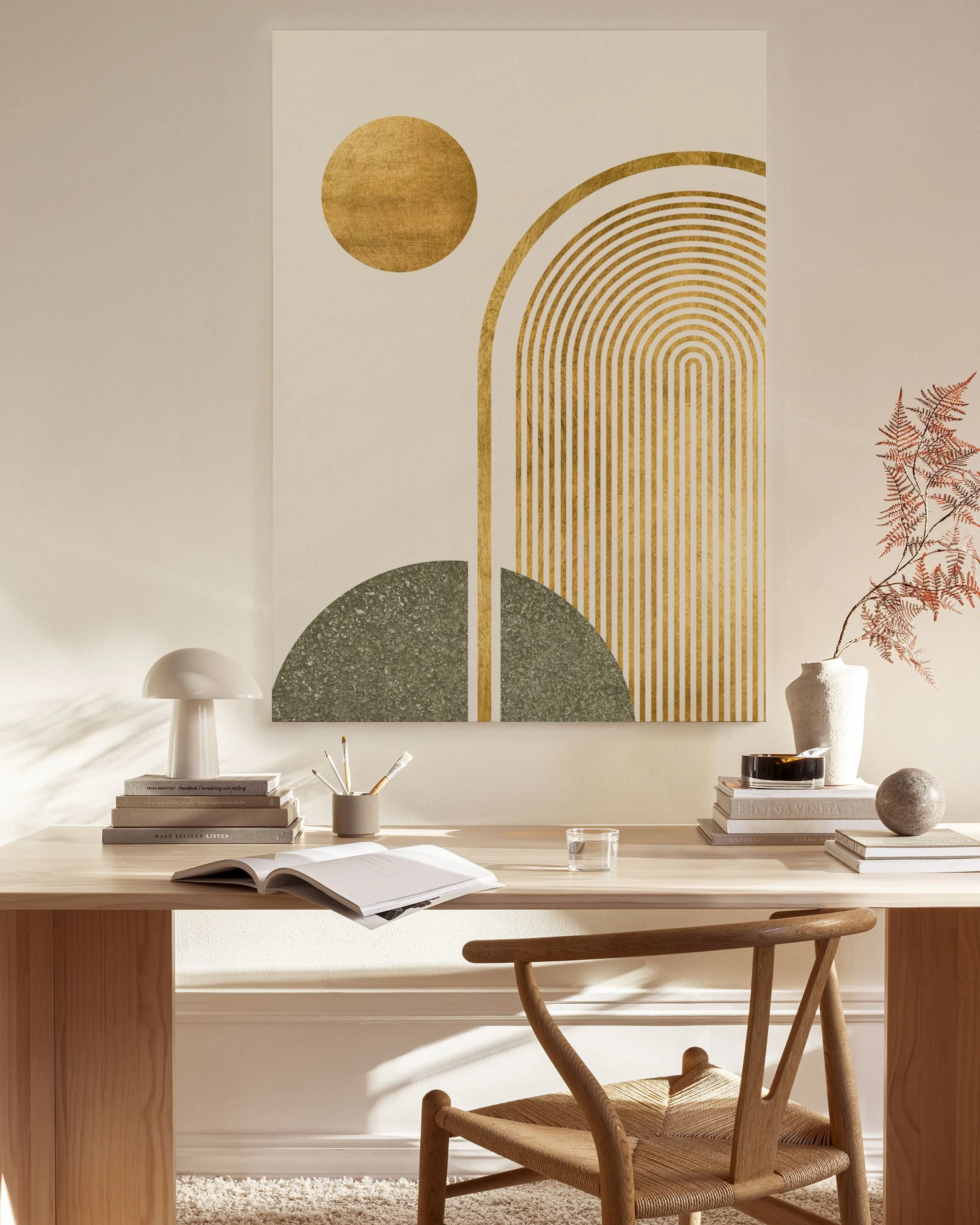 Tela decorativa com formas geométricas douradas e semi-círculos de granito cinzento, pendurada numa sala de estar minimalista.