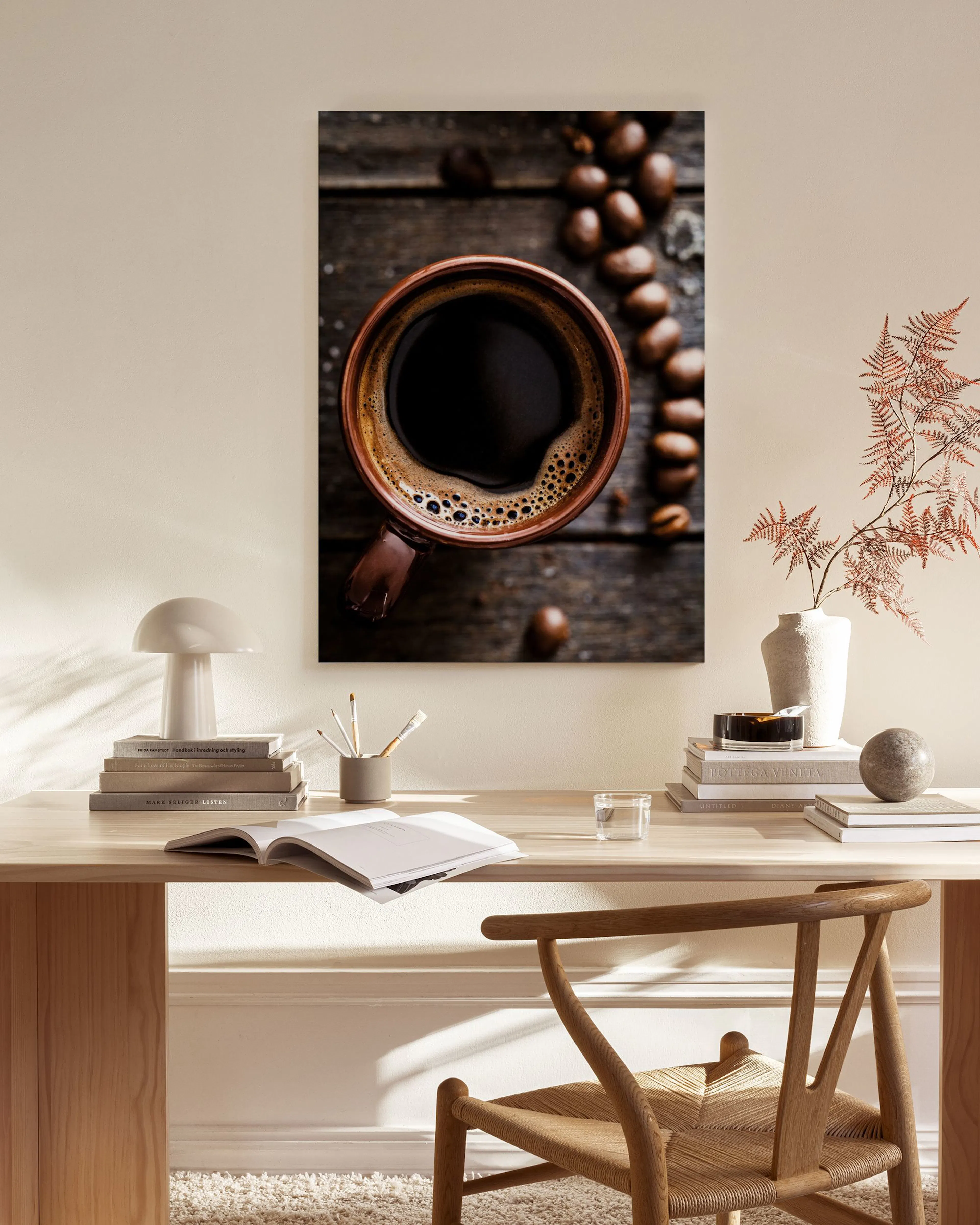 Lerretsbilde av kaffekopp og kaffebønner på mørkt treverk, henger i et moderne rom over en skjenk.