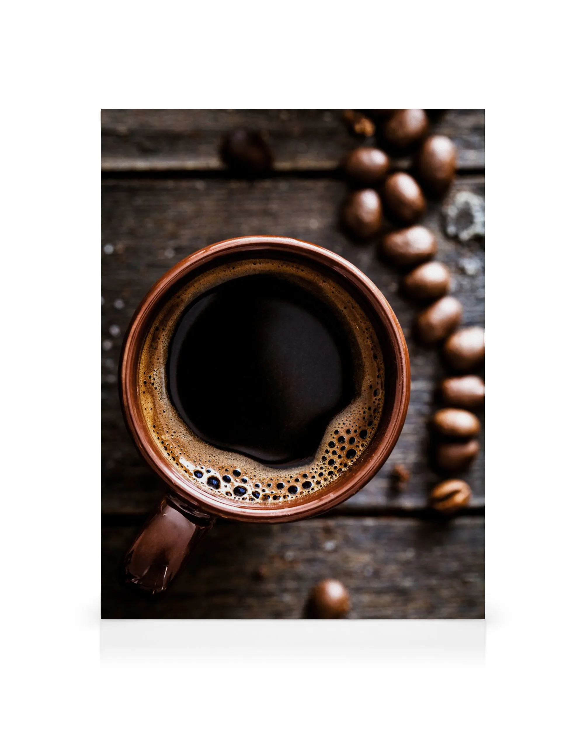 Close-up de xícara de café fumegante e grãos de café espalhados sobre uma mesa de madeira escura, ideal para amantes de café.