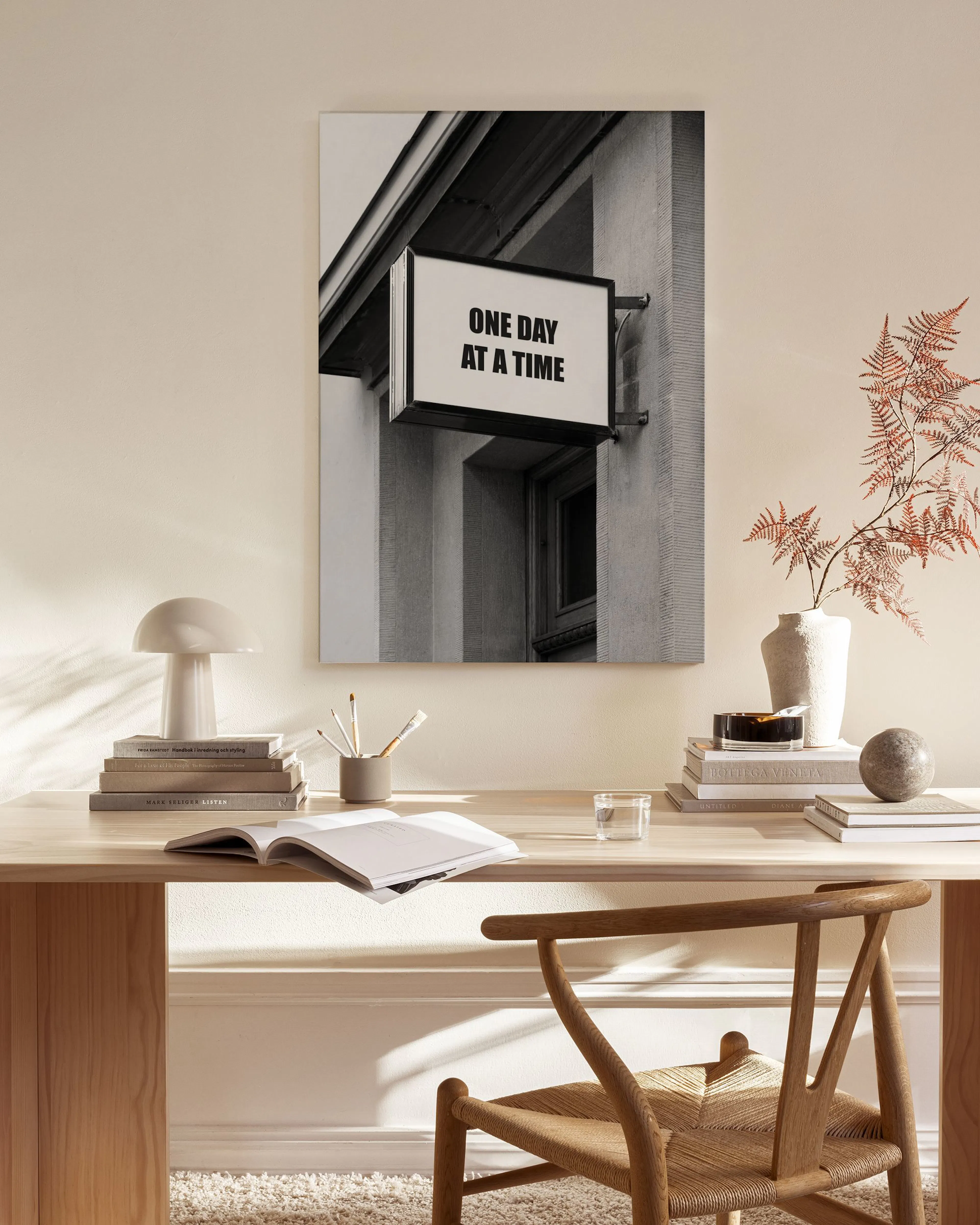 Schwarz-weißes Leinwandbild mit Leuchtreklame ONE DAY AT A TIME in einem modernen Wohnzimmer mit Holzmöbeln.