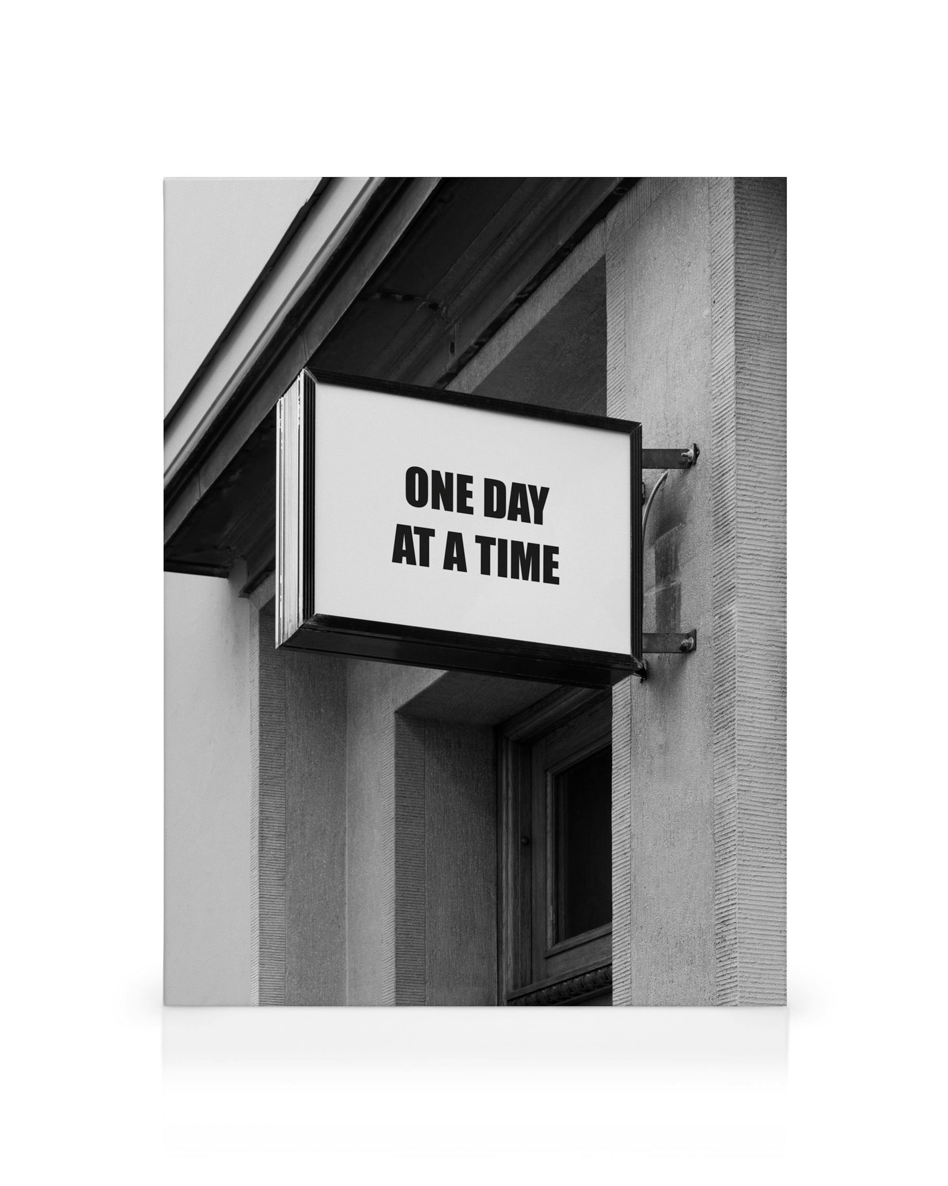 Toile noir et blanc avec le typographie One Day At A Time sur un panneau mural, style photographique