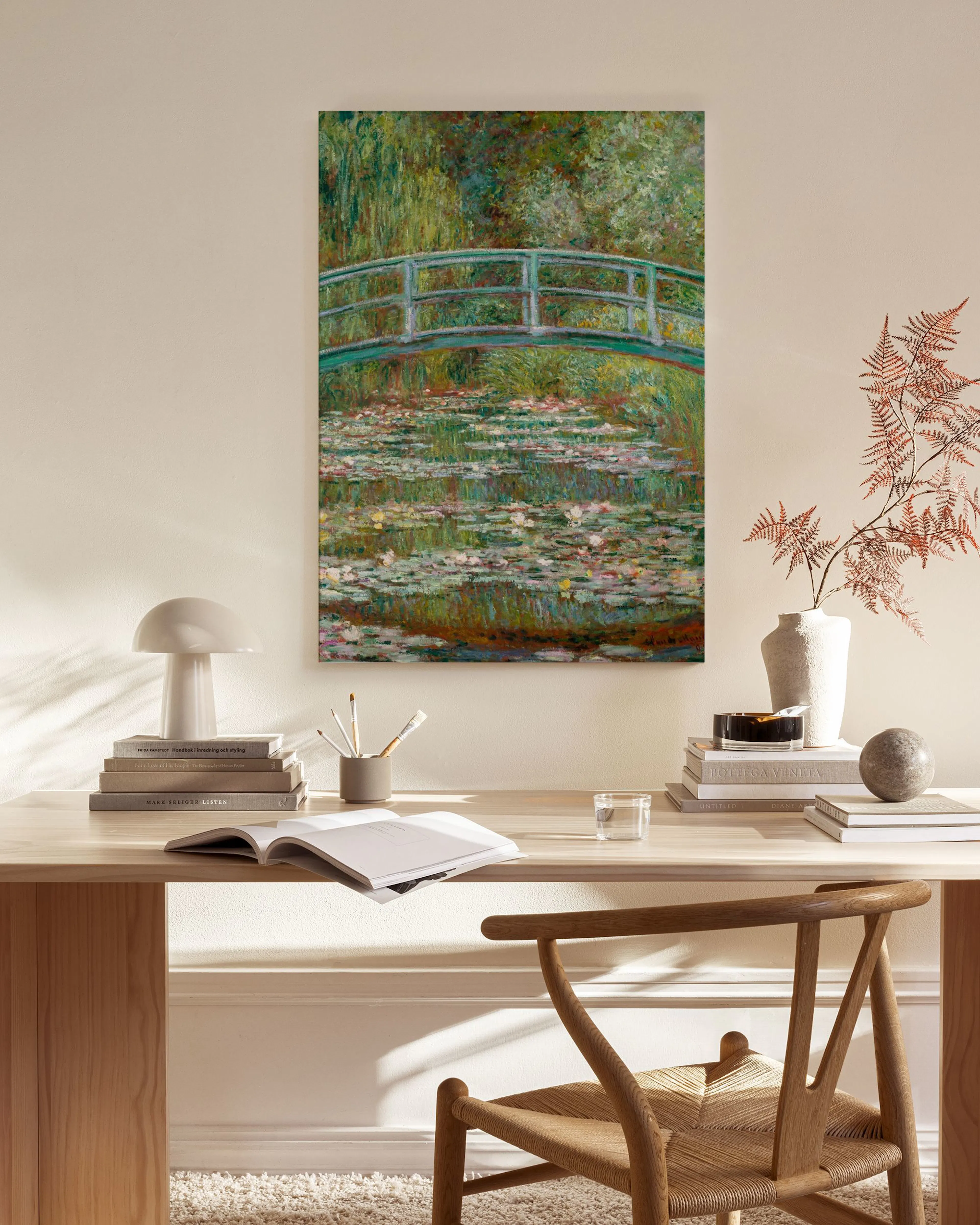Monets Water Lilies canvas print featuring a green bridge and lily pads, displayed in a modern living room.
