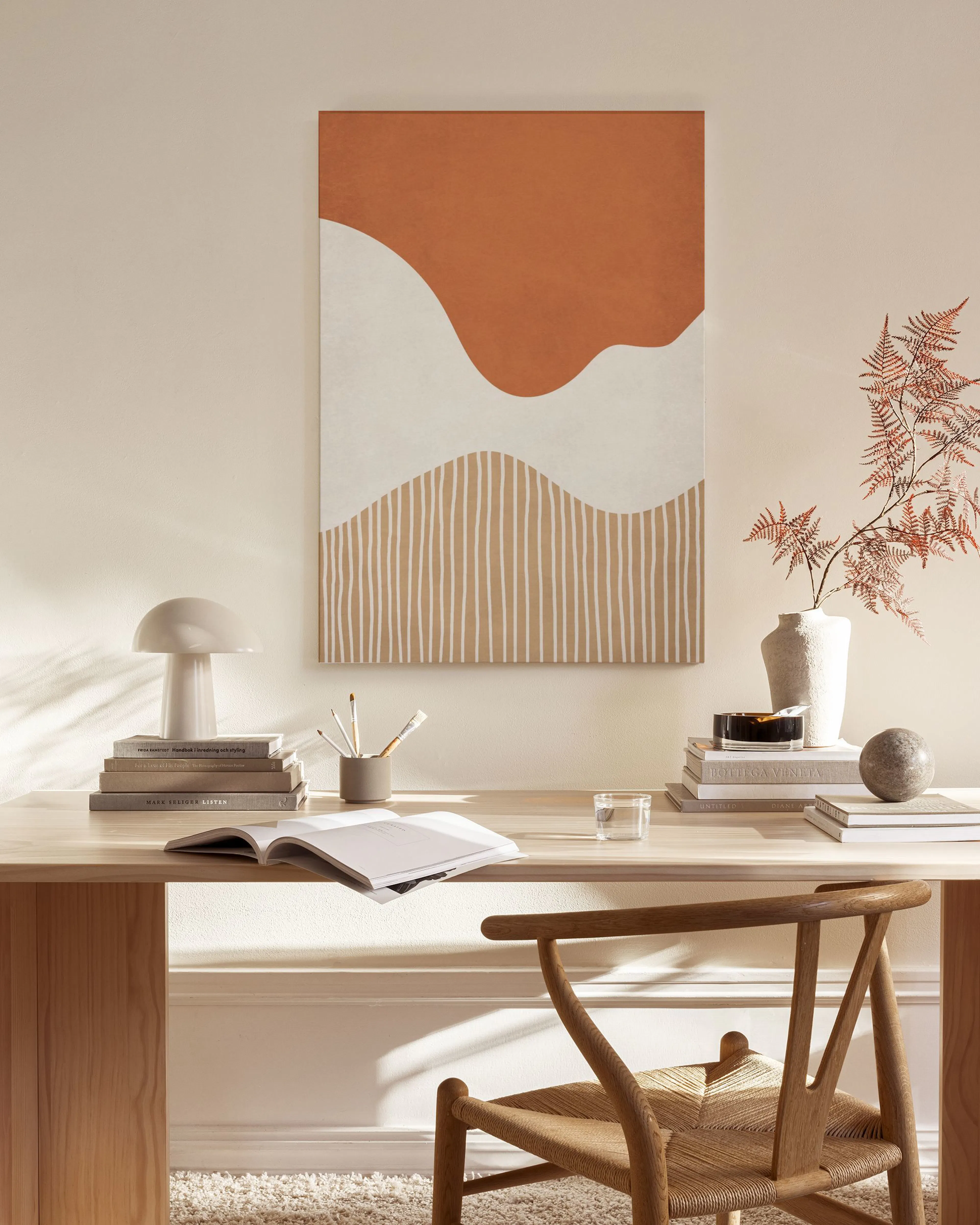 Toile abstraite aux formes organiques marron rouille et crème, avec des lignes verticales, dans un salon lumineux.