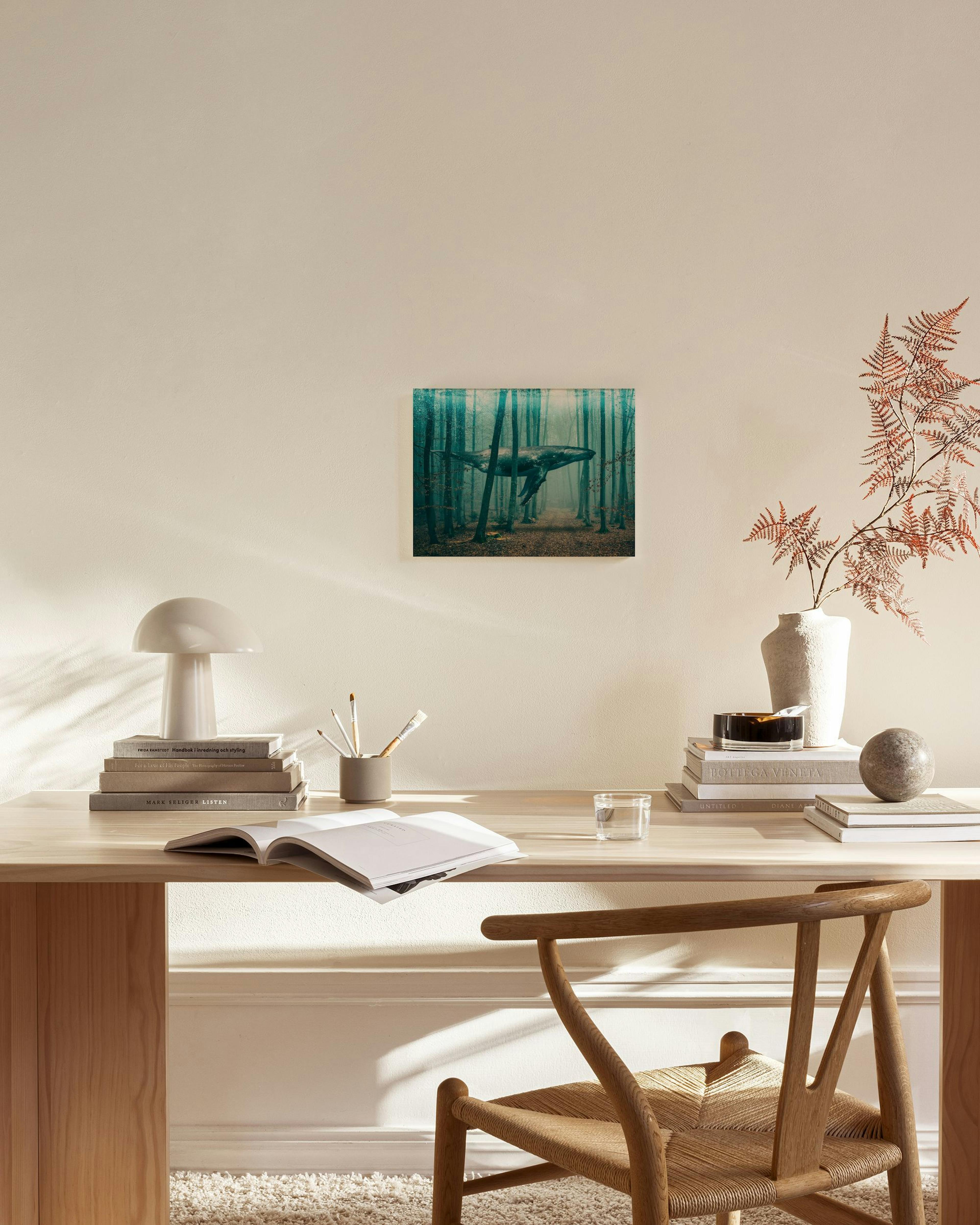 Lærred med en hval svævende over en skovbund med brune blade og tynde træstammer i tåge.