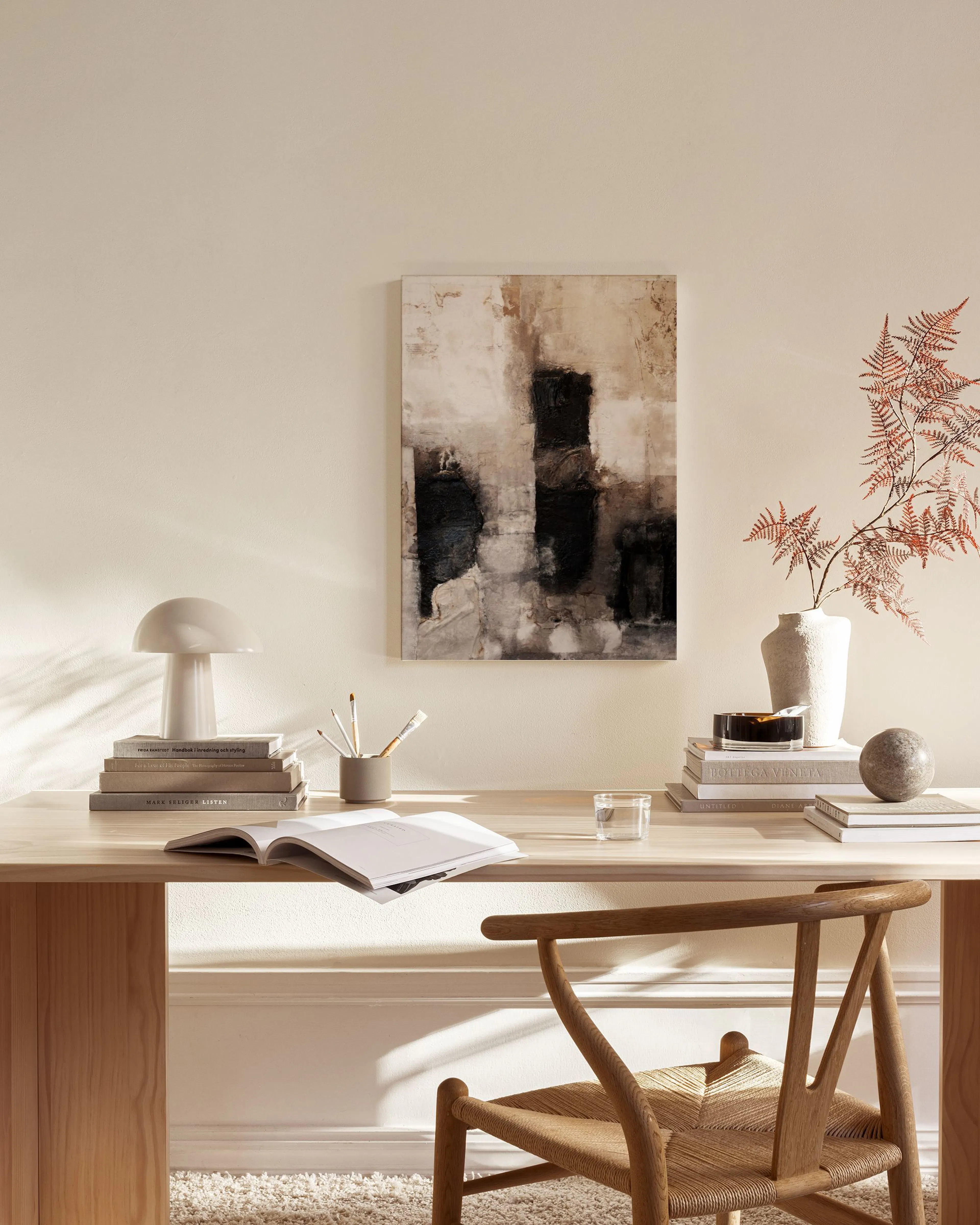 Abstraktes Leinwandbild mit schwarzen und beigen Farbtönen, hängend über einem Sideboard im Wohnzimmer.