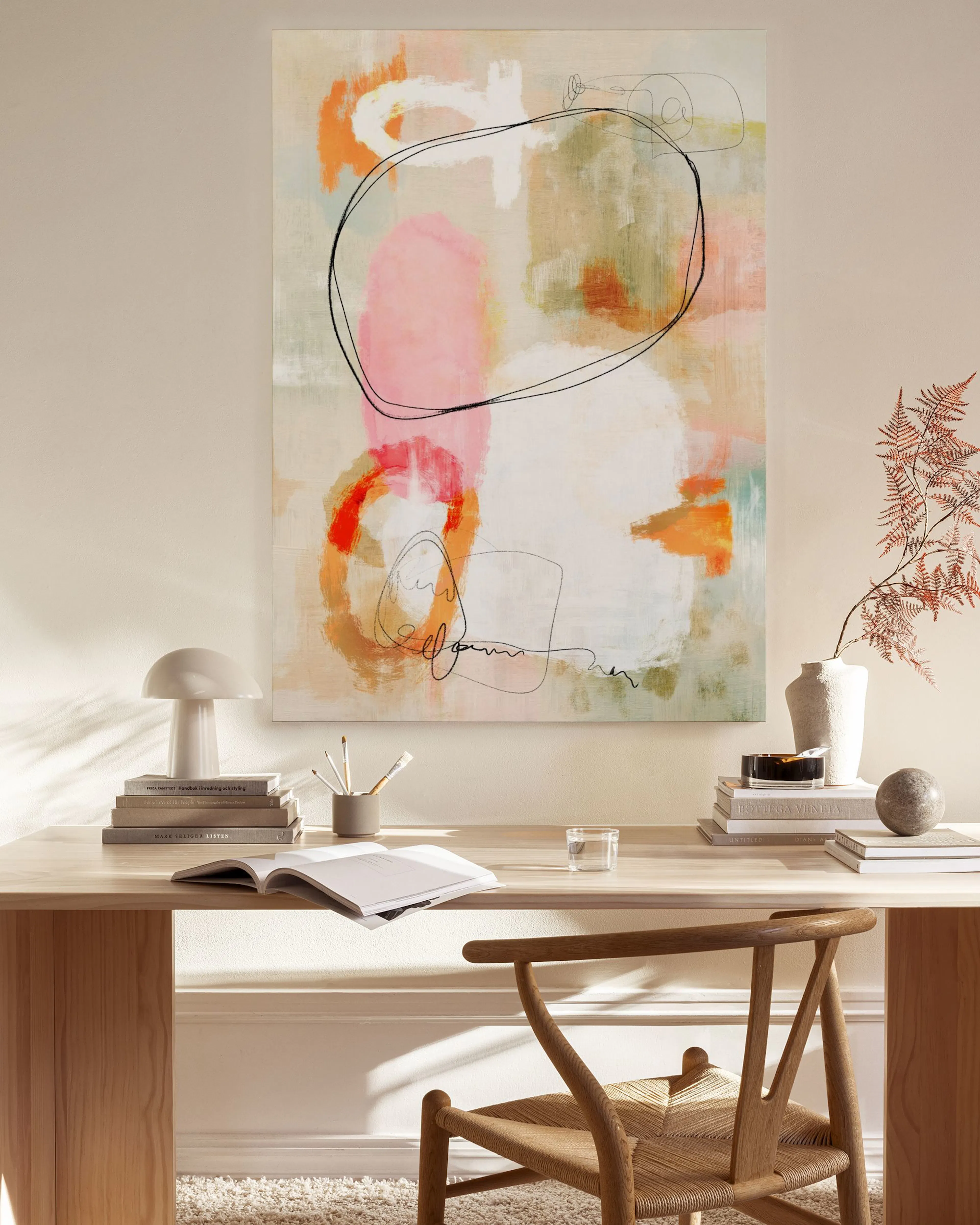 Leinwandbild mit abstrakten Formen in Rosa, Orange und Grün, akzentuiert mit dünnen schwarzen Linien, über einer Holzkonsole in 