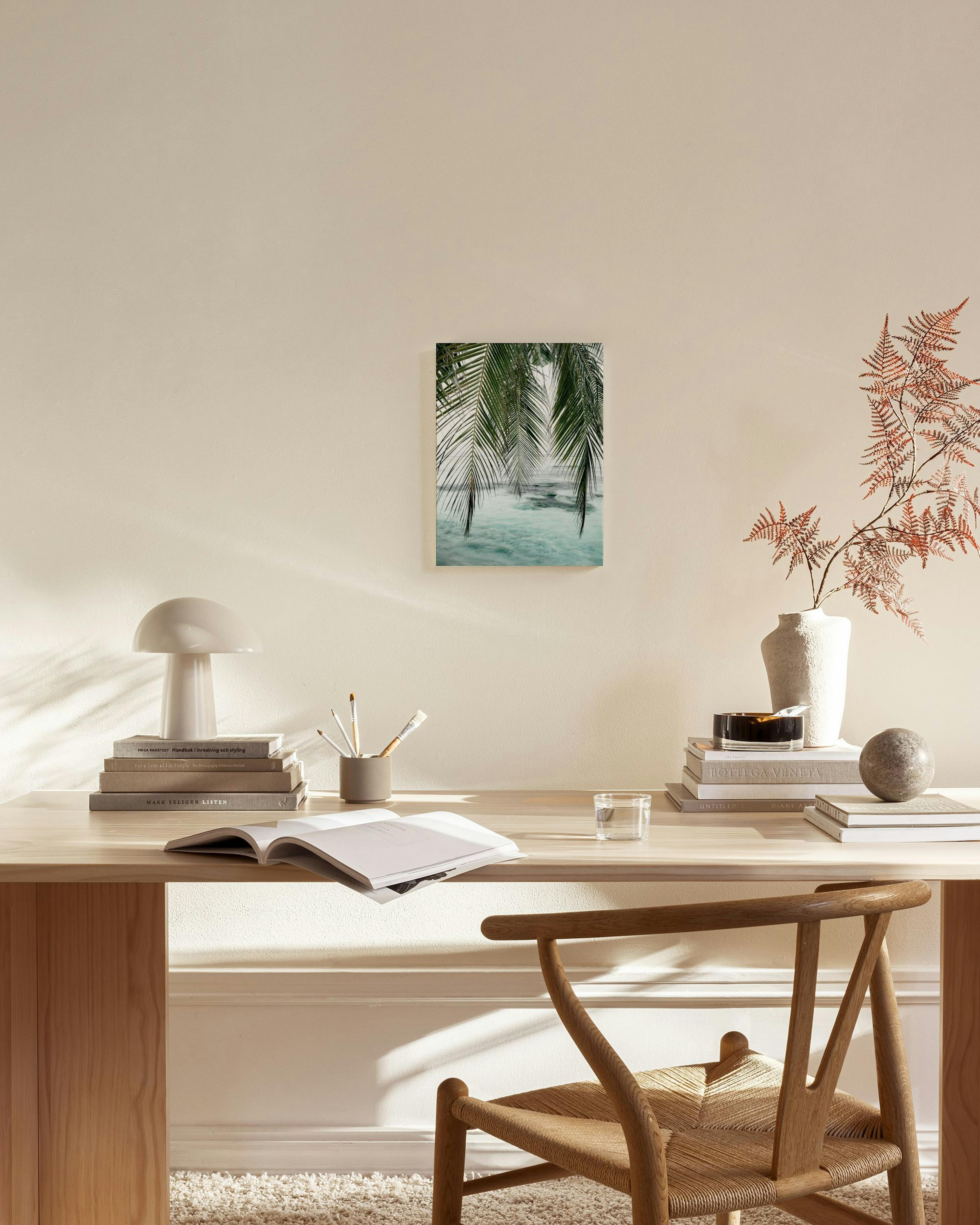 Toile de palmiers tropicaux sur locéan turquoise, exposée dans un salon moderne aux tons neutres.