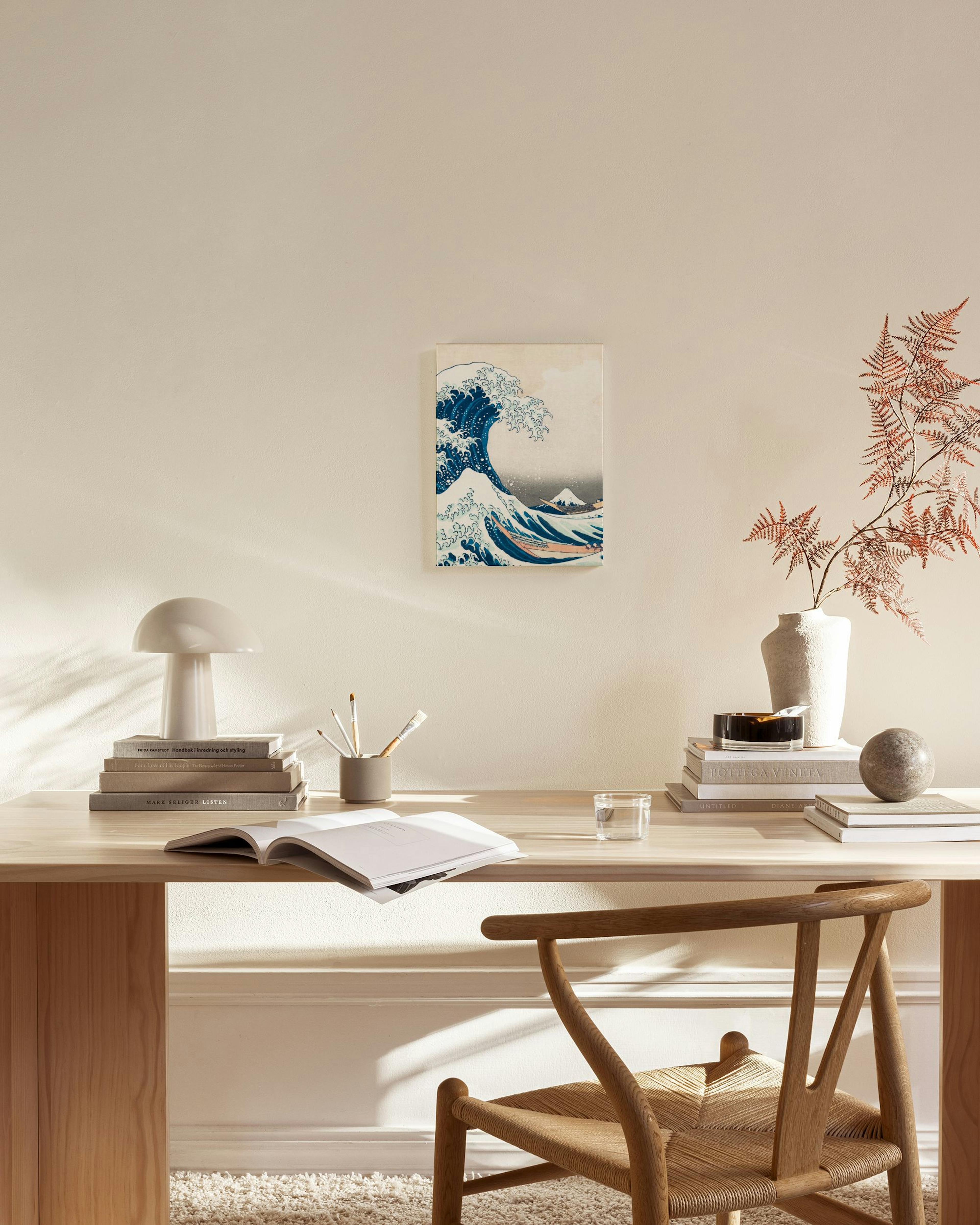 Canvastavla med Katsushika Hokusais Under vågen utanför Kanagawa, hängande i ett ljust vardagsrum med trädetaljer.