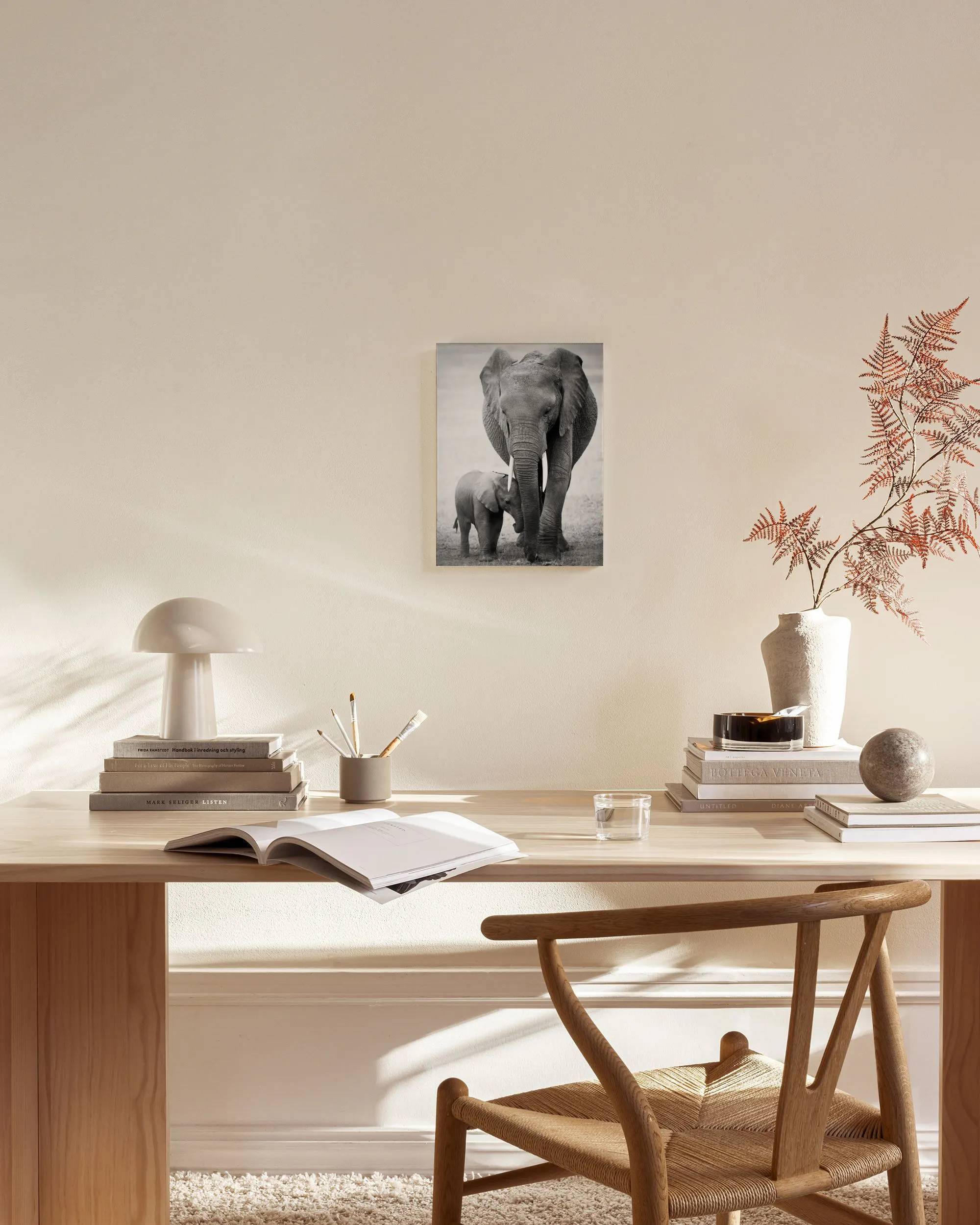 Black and white canvas print of a mother elephant and her calf, displayed in a modern living room.