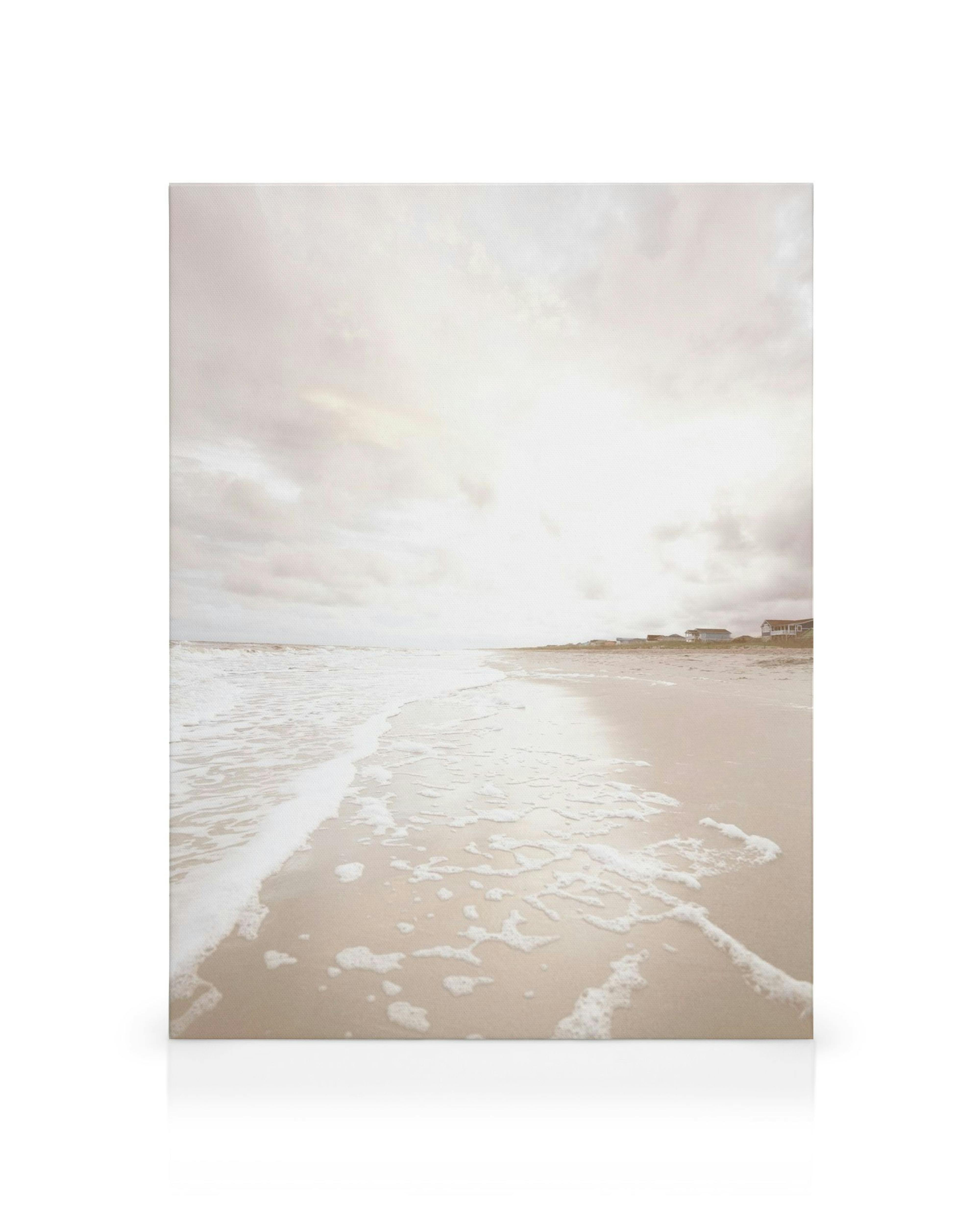 Canvastavla med strandlandskap i lugna, ljusa toner. Vågor sköljer in över sandstrand under molnig himmel. Idealiskt för strandä